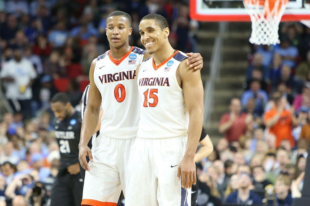 Two basketball players wrapping an arm around each other on the court