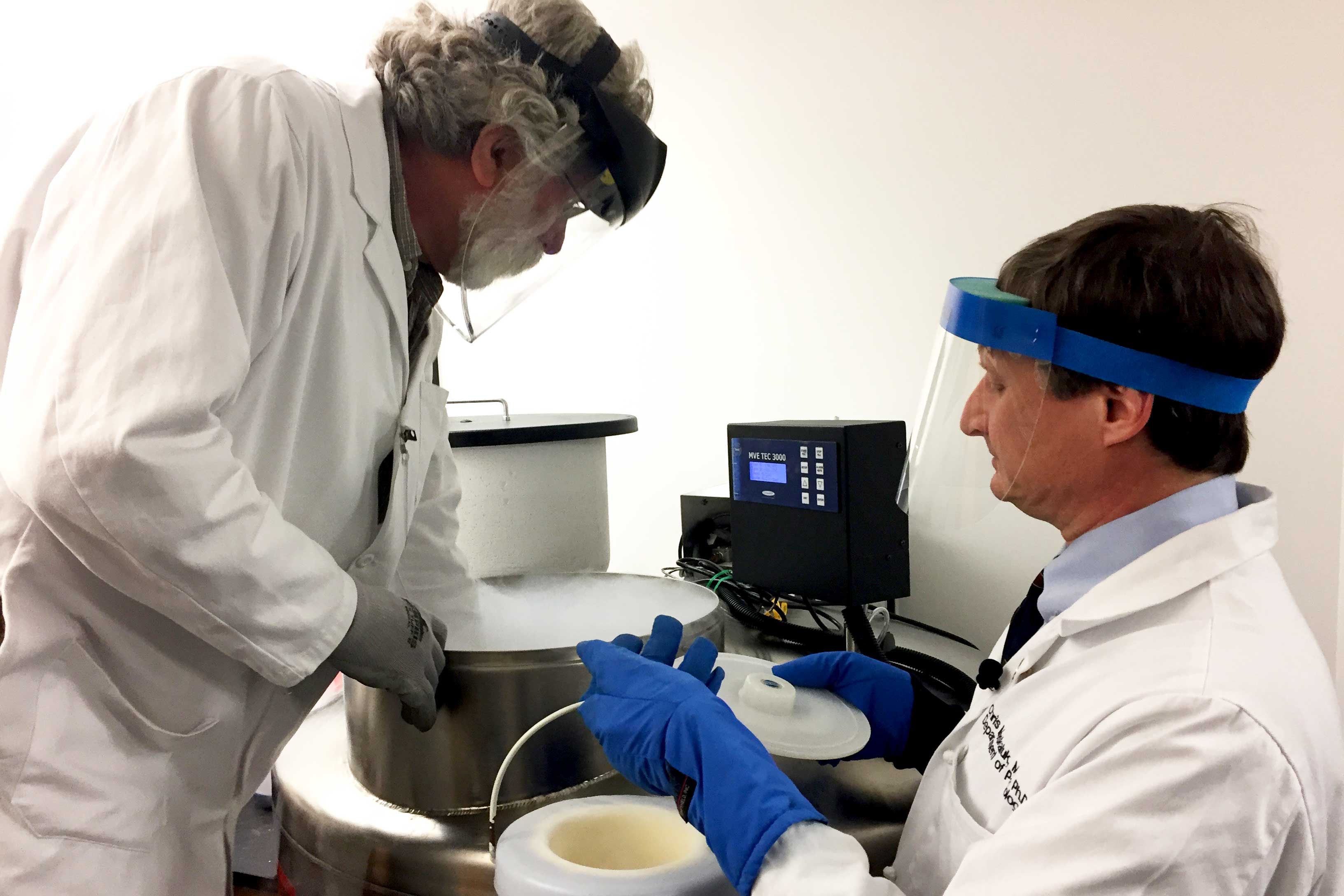 Dr. Christopher Moskaluk, right, works with another person in a lab