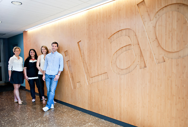 Group of individuals stand next to the iLab sign