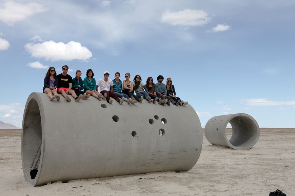 Students sitting on massive concrete tubes called sun tunnels