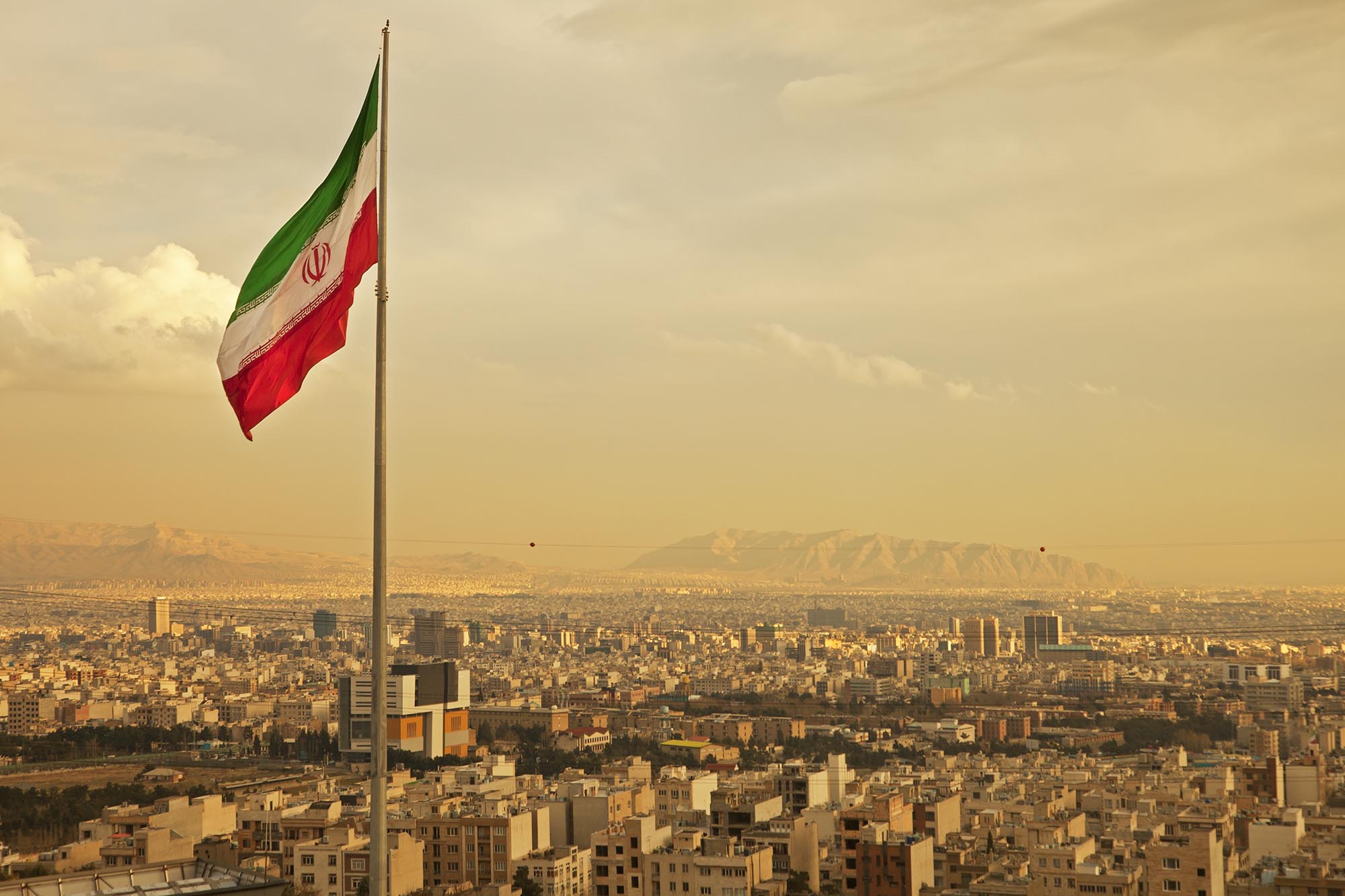 Iranian flag flying above an Iranian city
