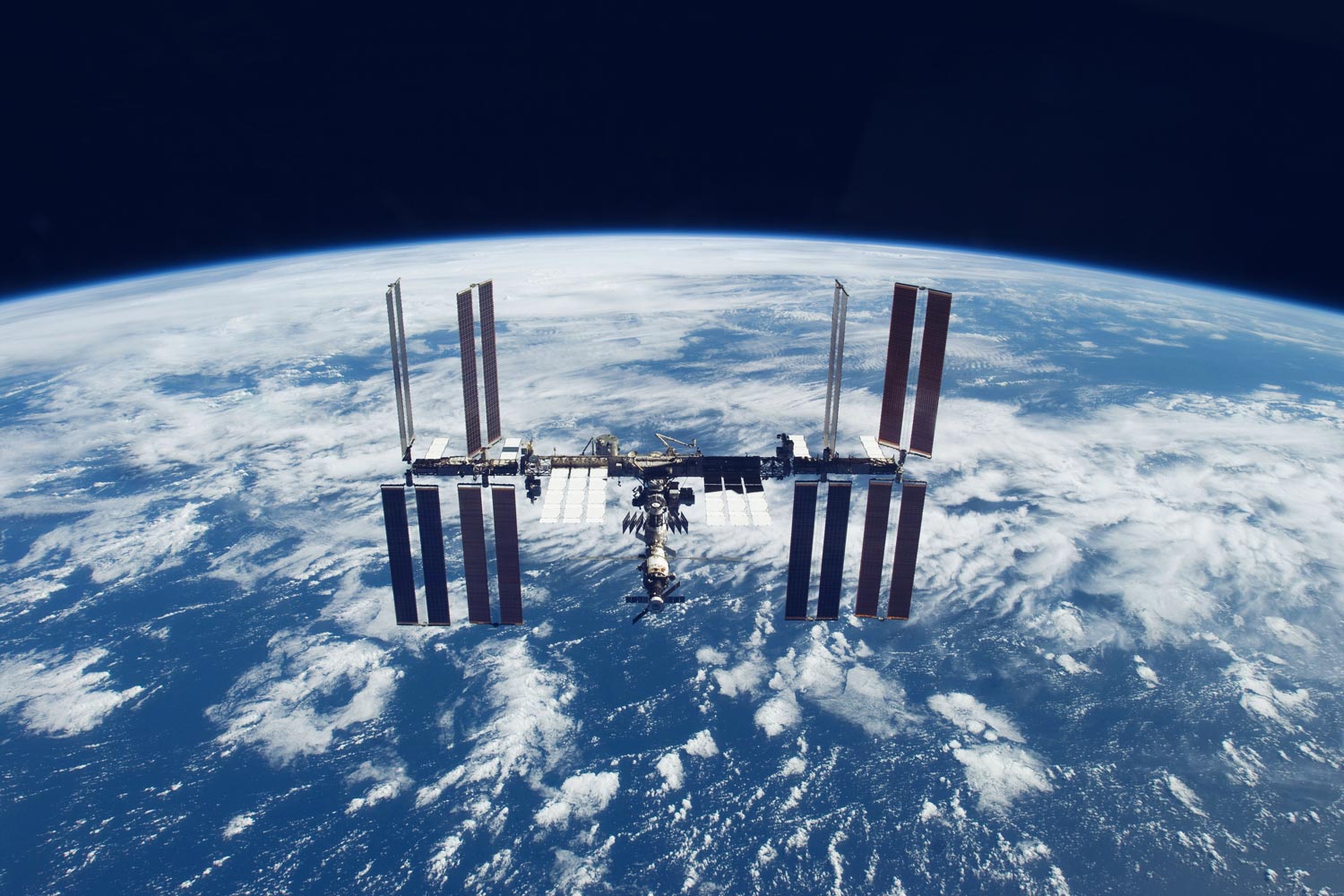 International Space Station with the cloudy earth below