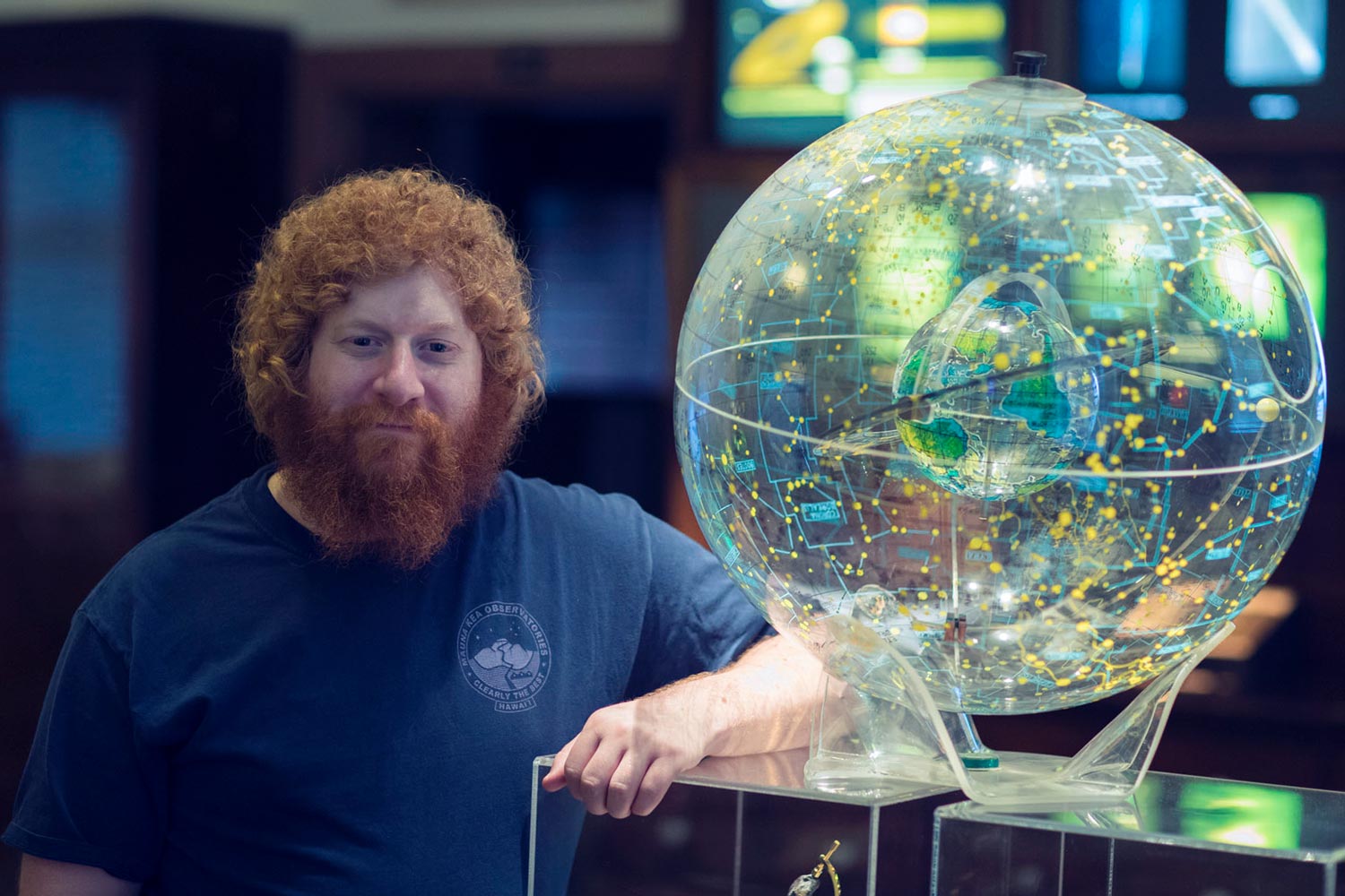 Ph.D. candidate Jake Turner stands next to a model of a planet