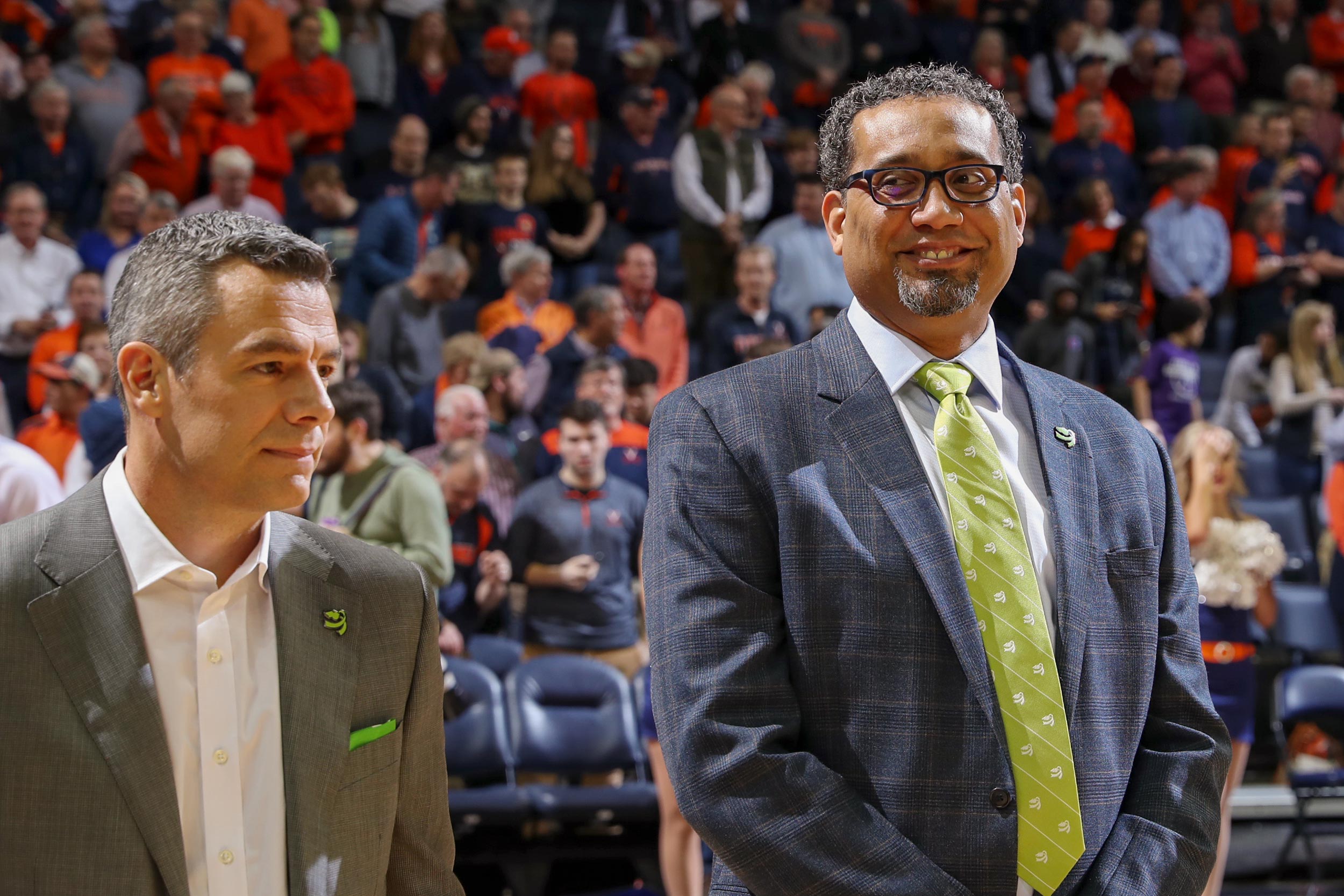 Jason Williford, right, stands next to Tony Bennett on the basketball court