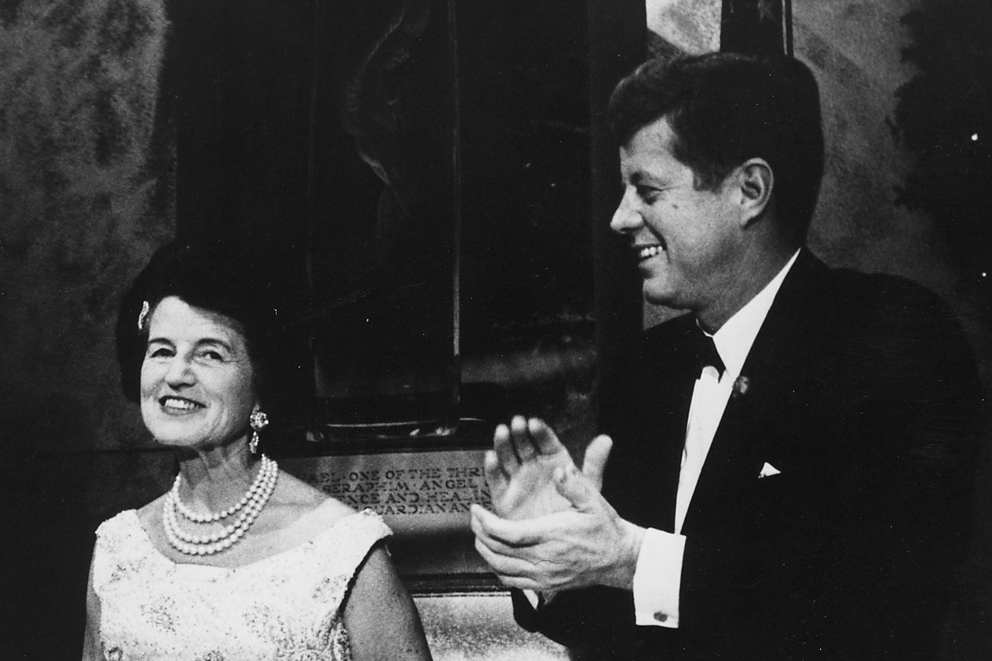 John F Kennedy clapping while looking at his mother, Rose Kennedy, left