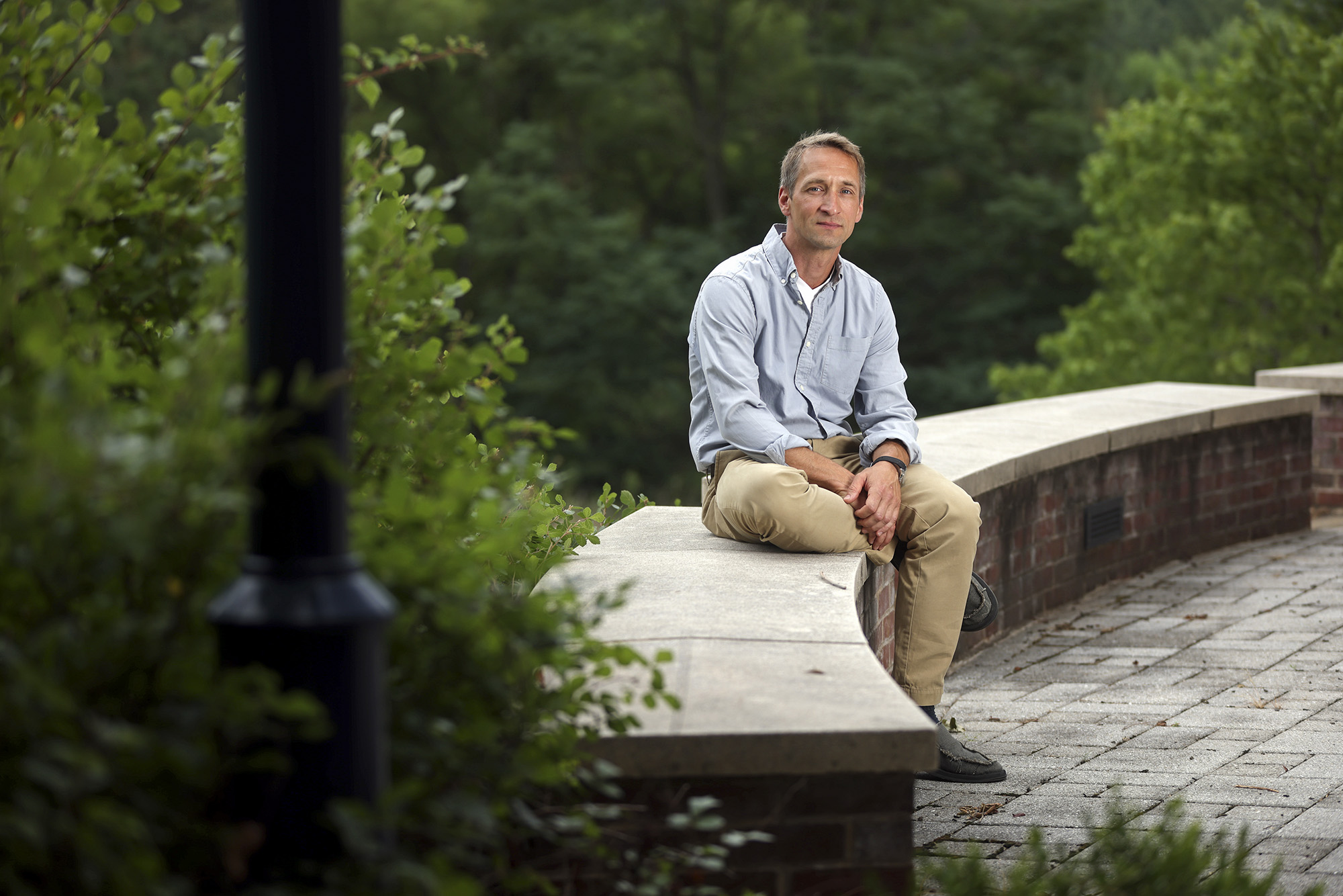 Jochen Zimmer sitting on a wall looking at the camera