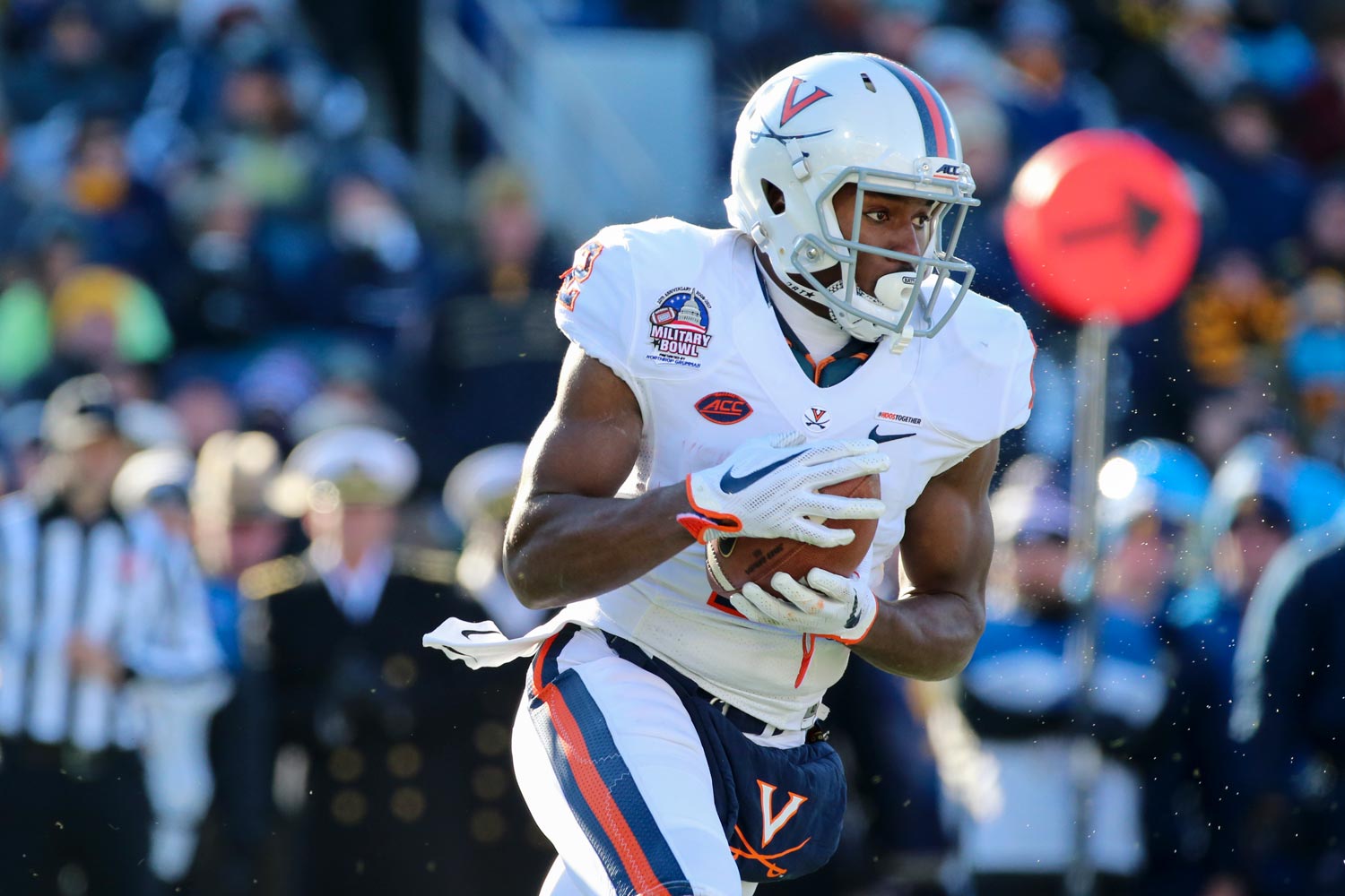 Joe Reed holding the football running down the  field during a UVA football game