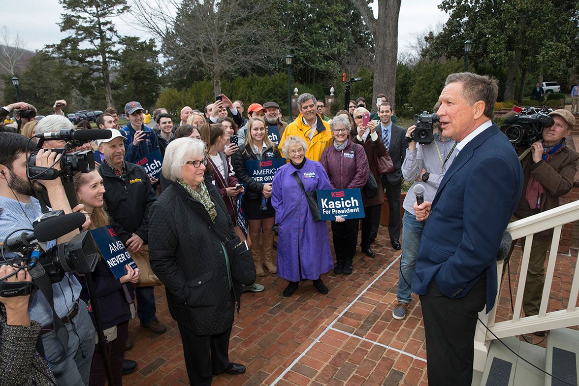 Gov. John Kasich stands on the steps of the Miller Center talking to a crowd of people