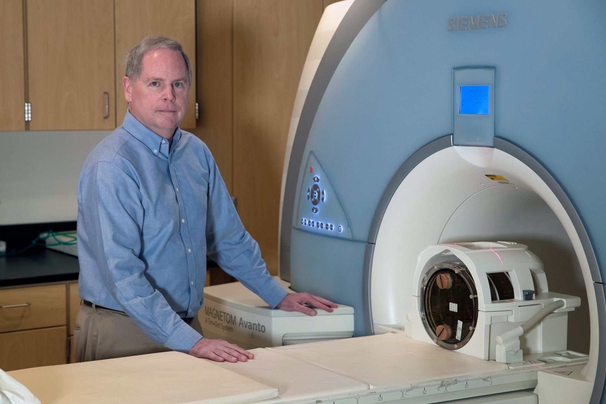 ohn Mugler stands next to a MRI machine