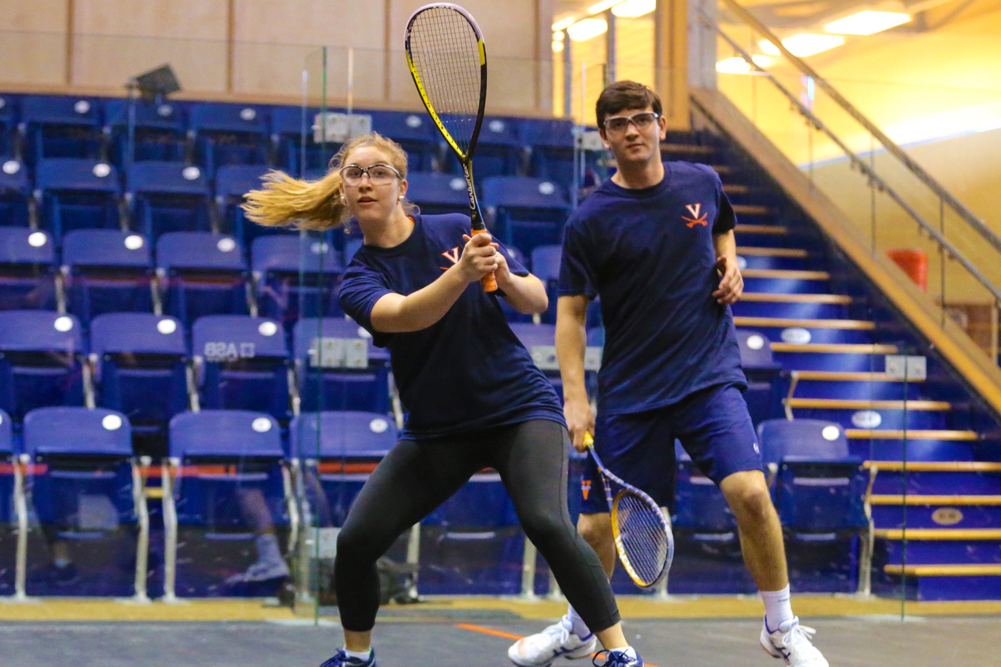 squash players Julia Thompson and Harrison Kapp playing in a court