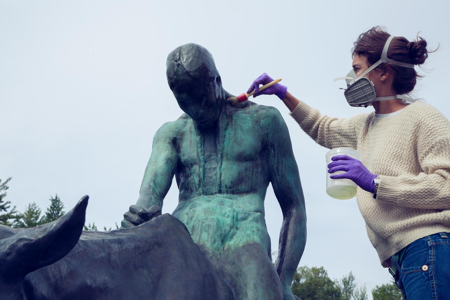 Conservator Kate McEnroe working on a statue 