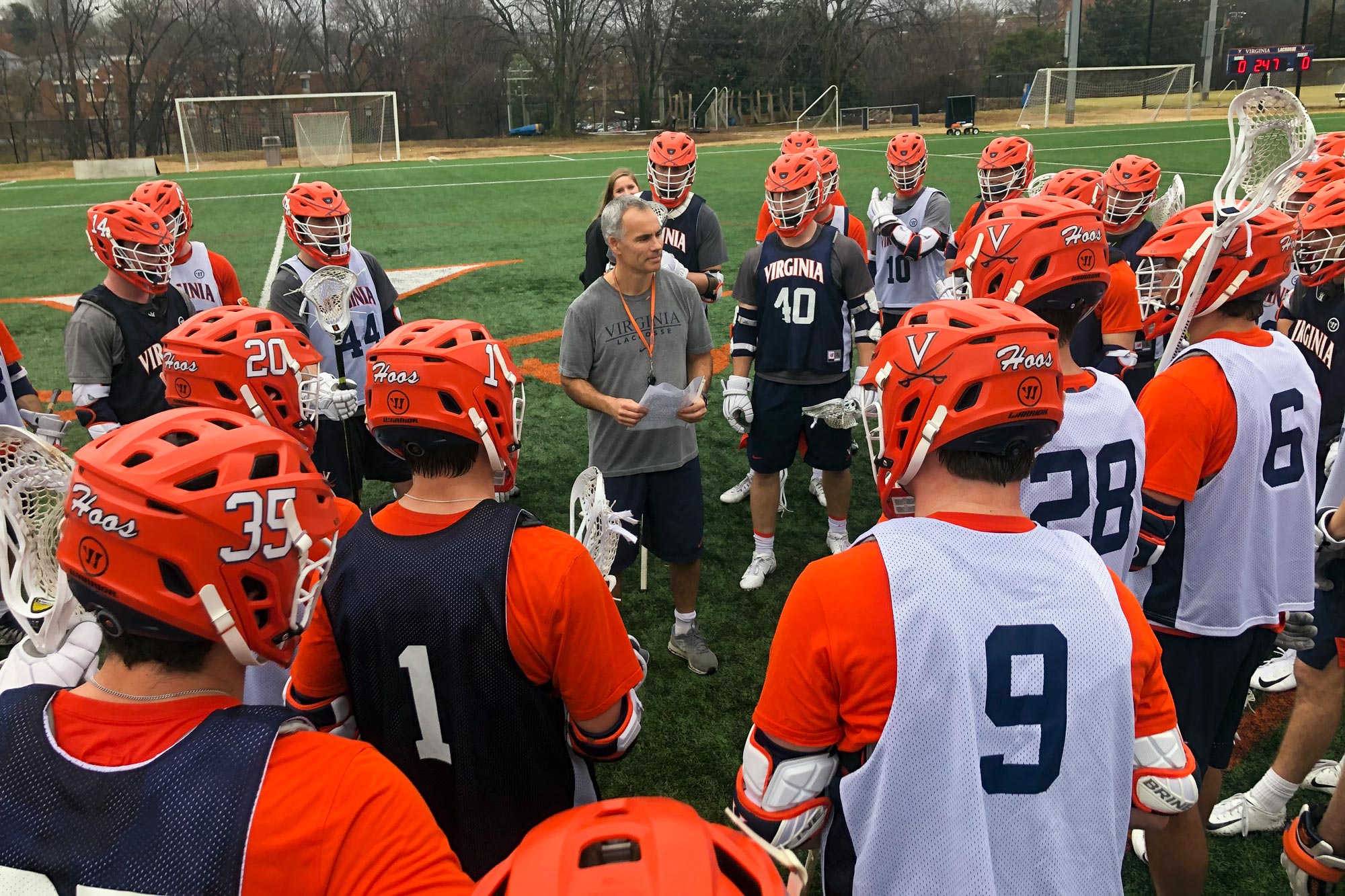 Lars Tiffany speaking to the mens lacrosse team during practice as they huddle around him