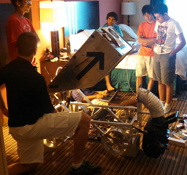 Students working on a robot in a hotel room