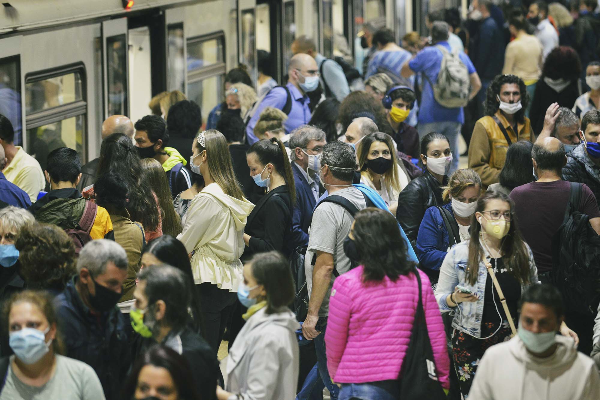 Subway station packed with people wearing masks