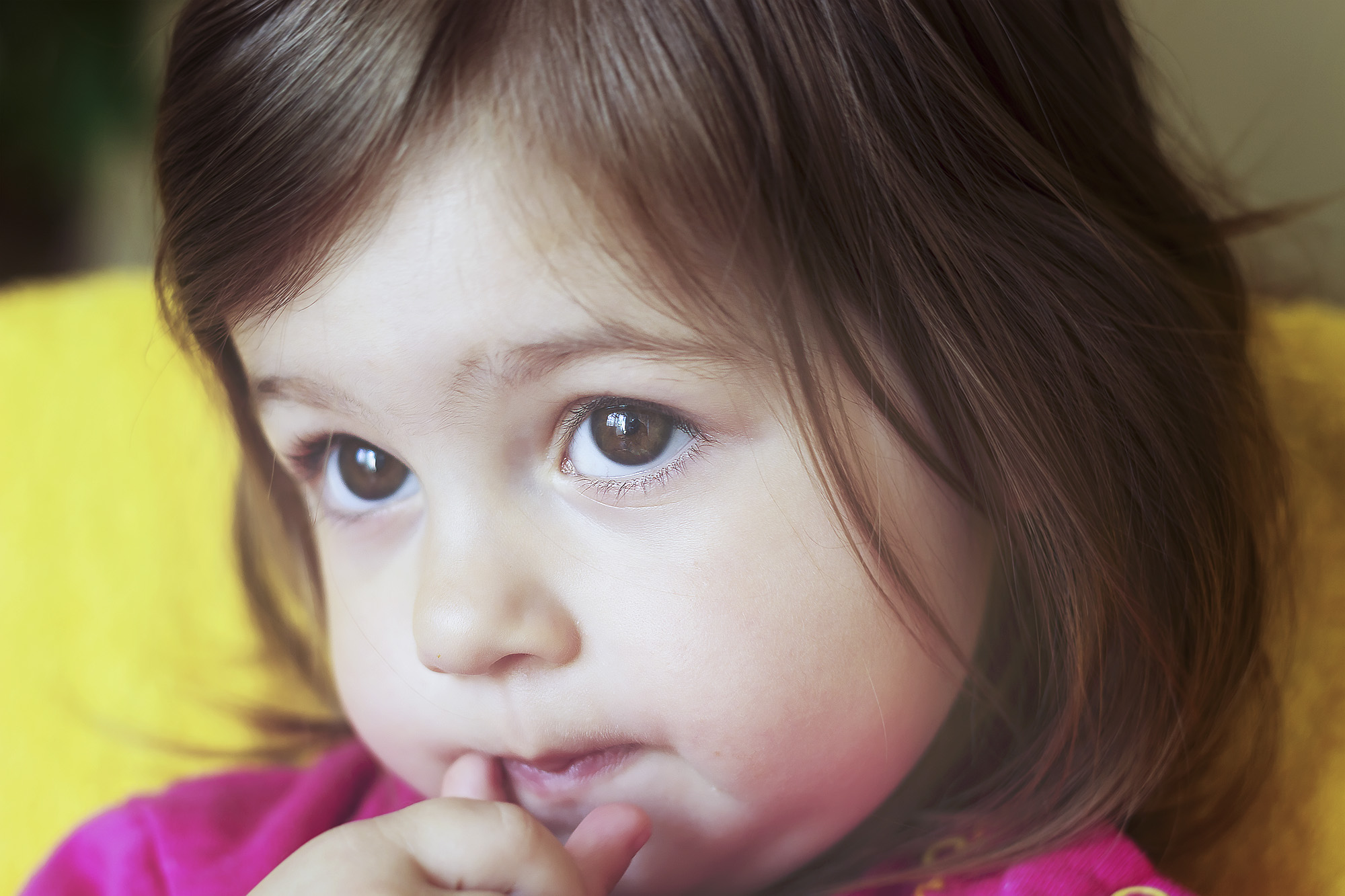 close up of a little girls face with brown hair and brown eyes