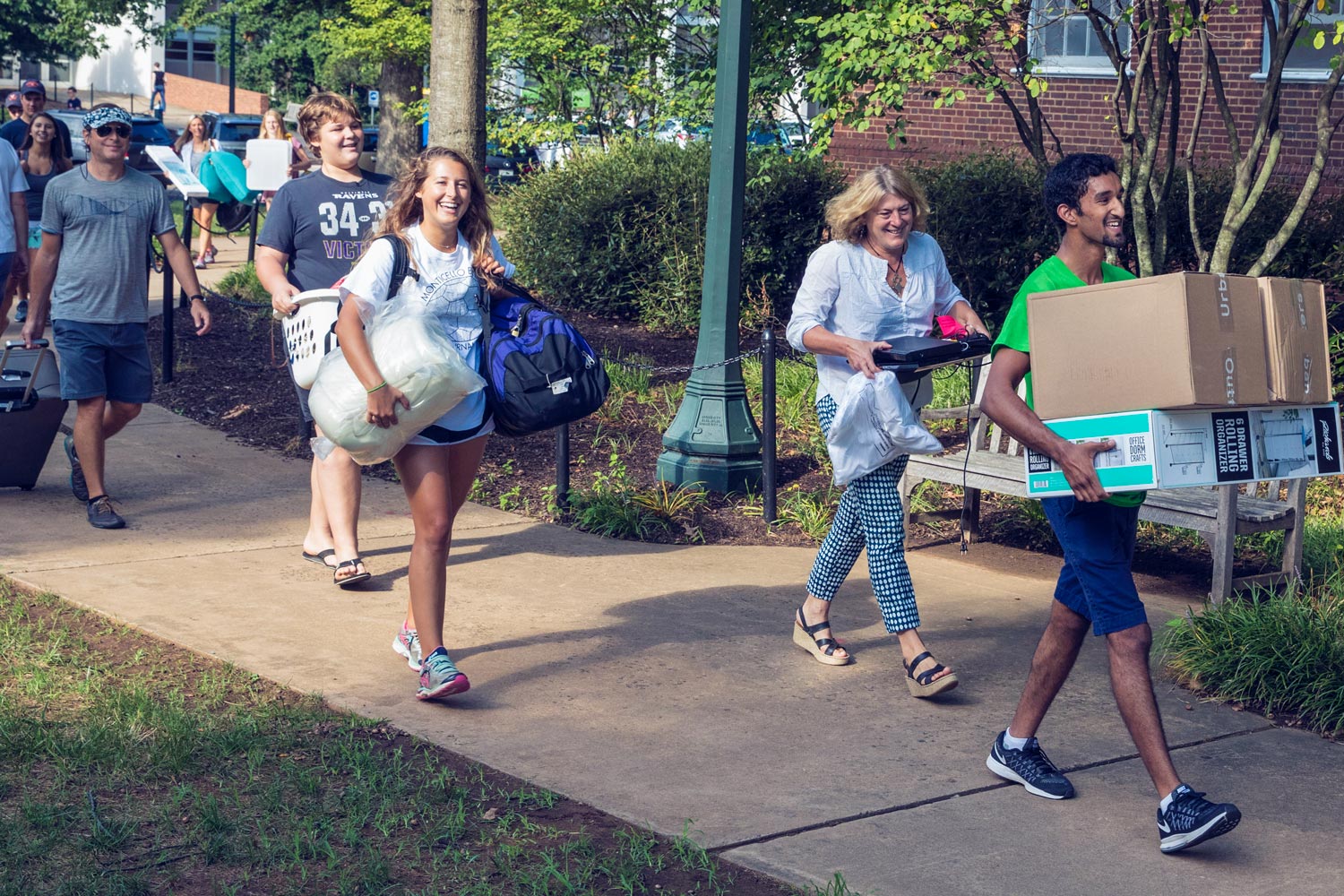 Students and parents carrying their belongings into a dorm