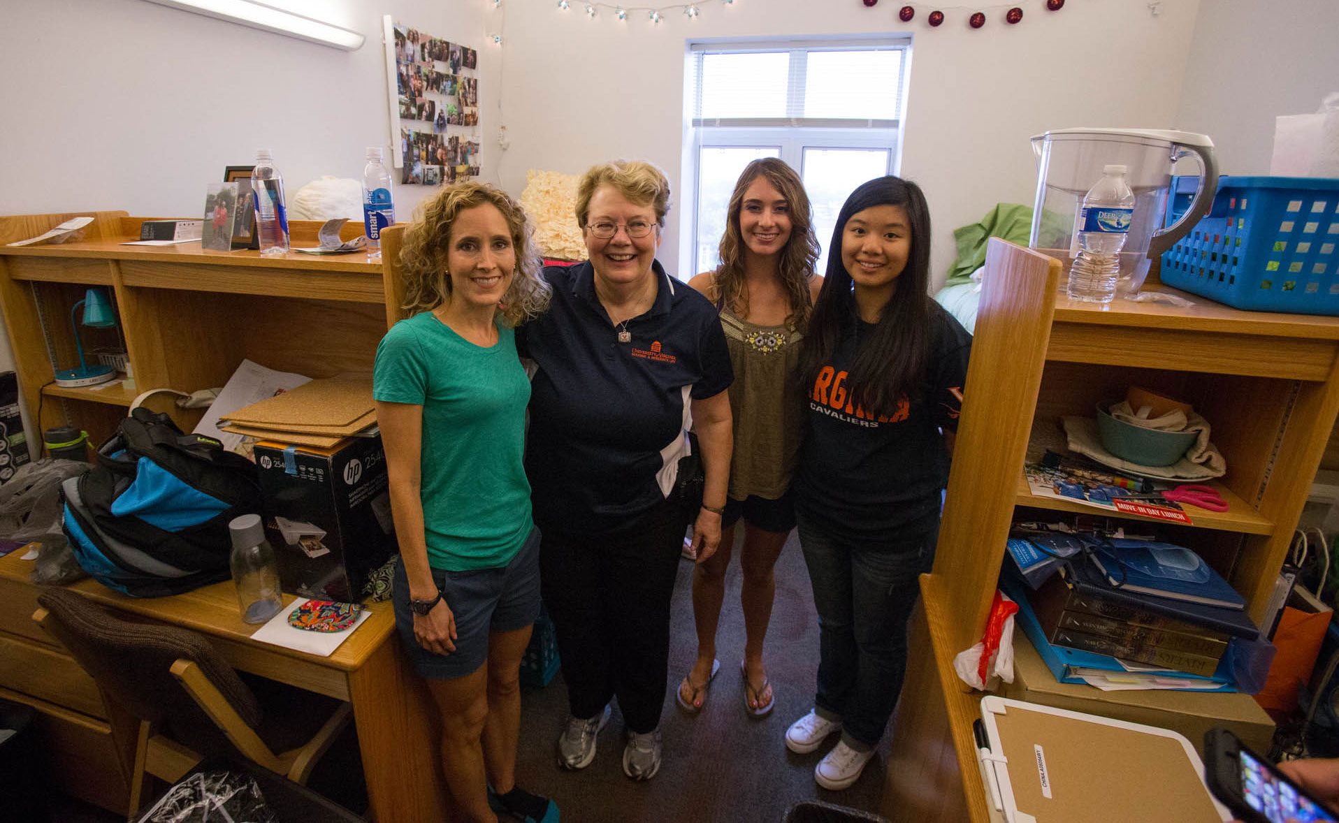 President Sullivan poses with two students and a parent inside of a dorm room