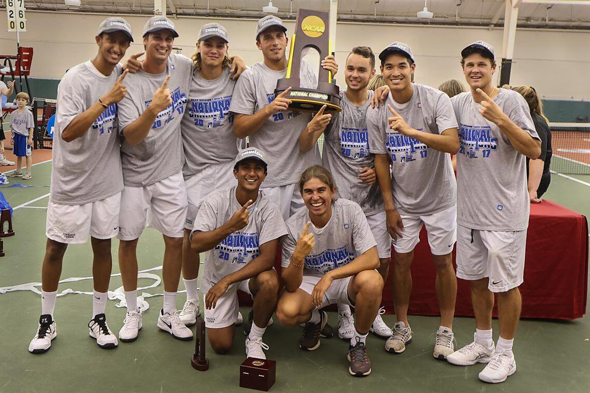 The UVA Mens tennis team stands together with their NCAA trophy