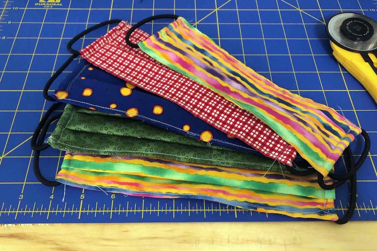 Colorful Masks sitting on a seamstress' cutting board