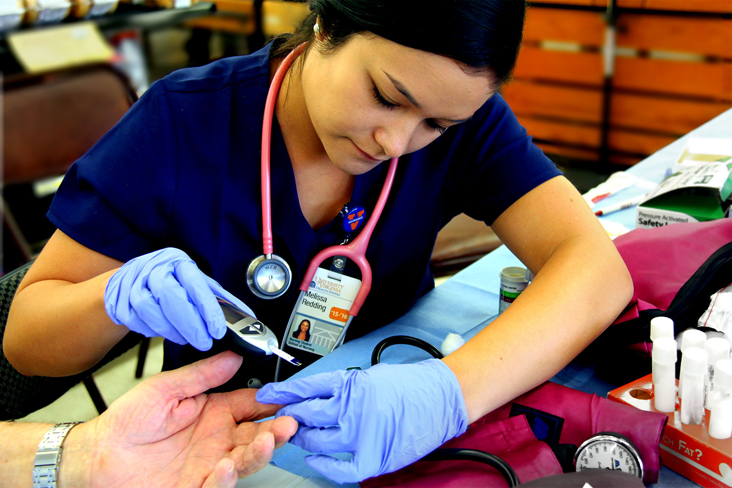 Nurse getting blood from a finger stick to test the blood sugar of a patient