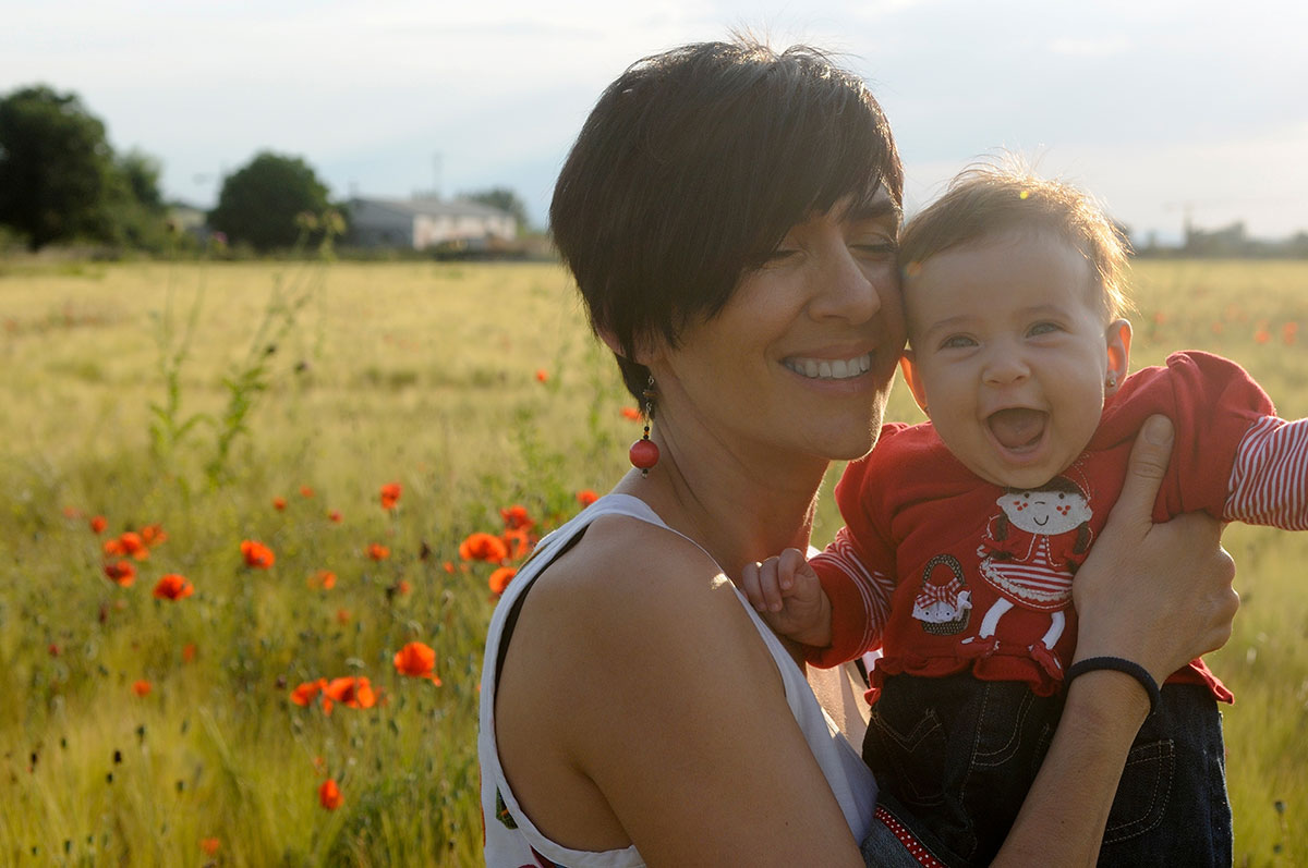 woman holding a baby in a field