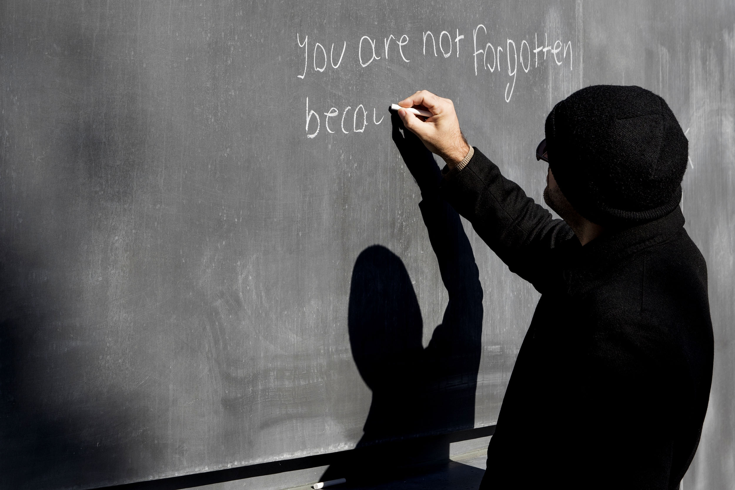 Person writing on a chalk board