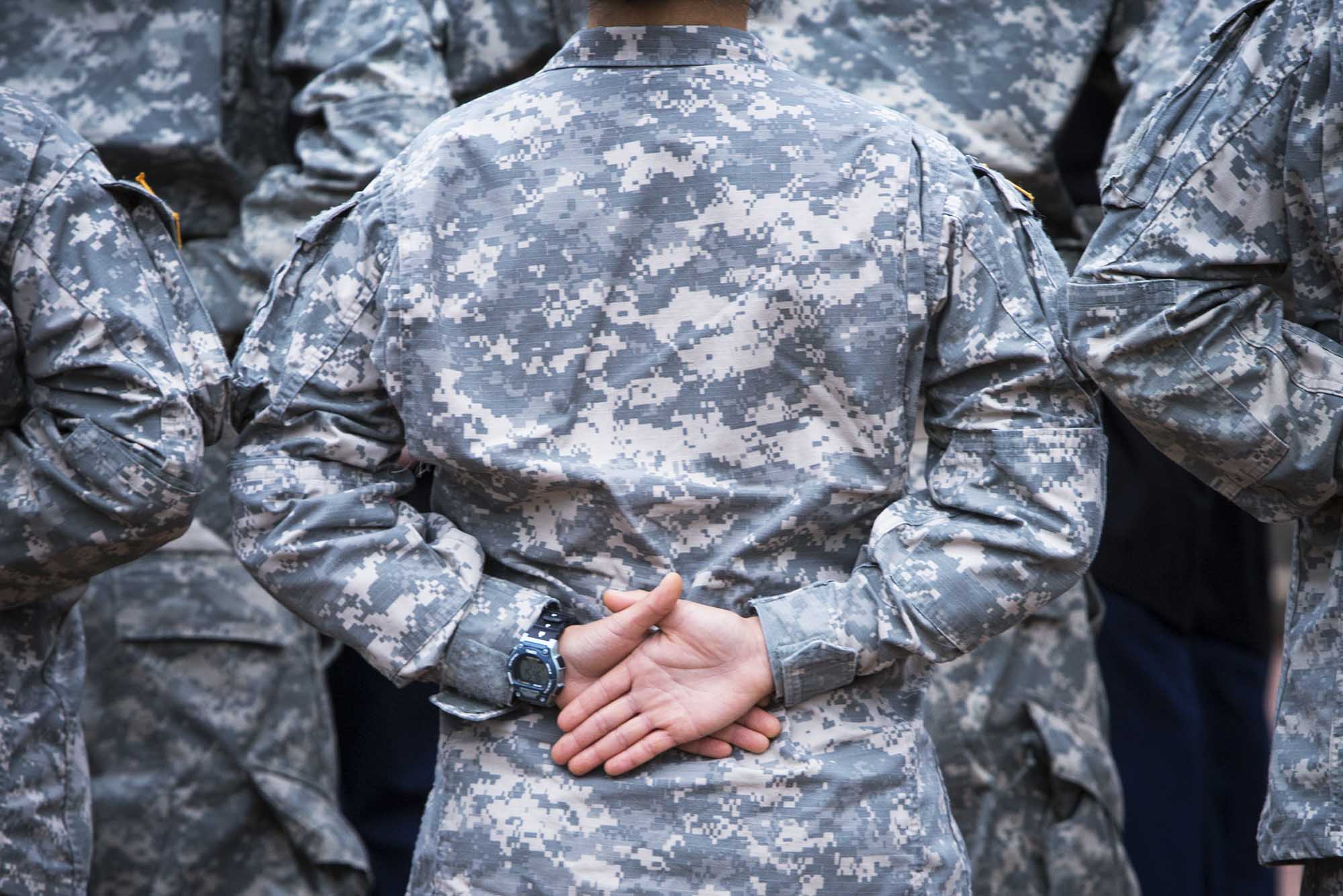 United States Army ROTC Cadets stand with their hands behind their back