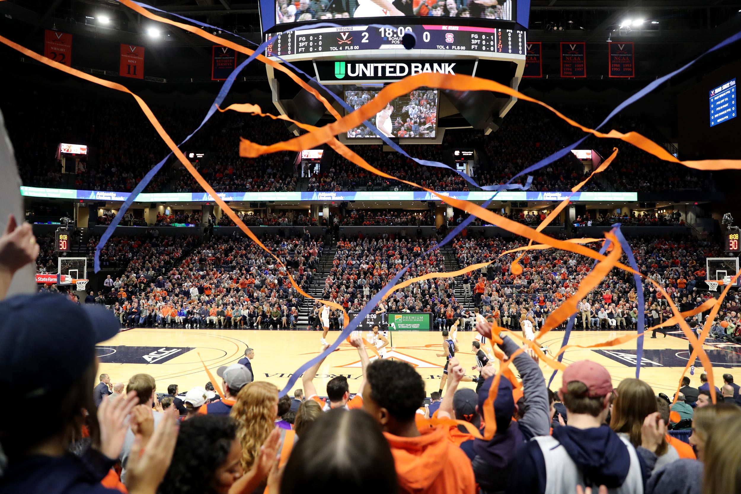 Blue and orange streamers being thrown during a basketball game