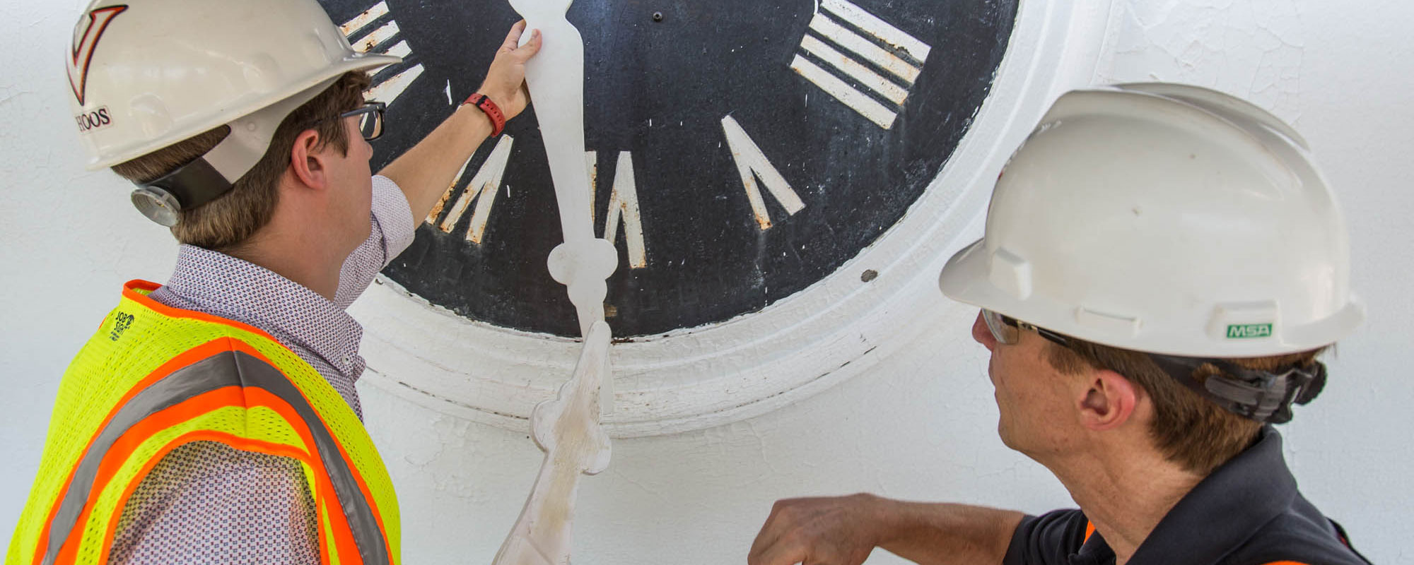 Christian Kochuba, left, and conservator Mark Kutney examine a wooden hand made for the Rotunda’s south portico clock. 