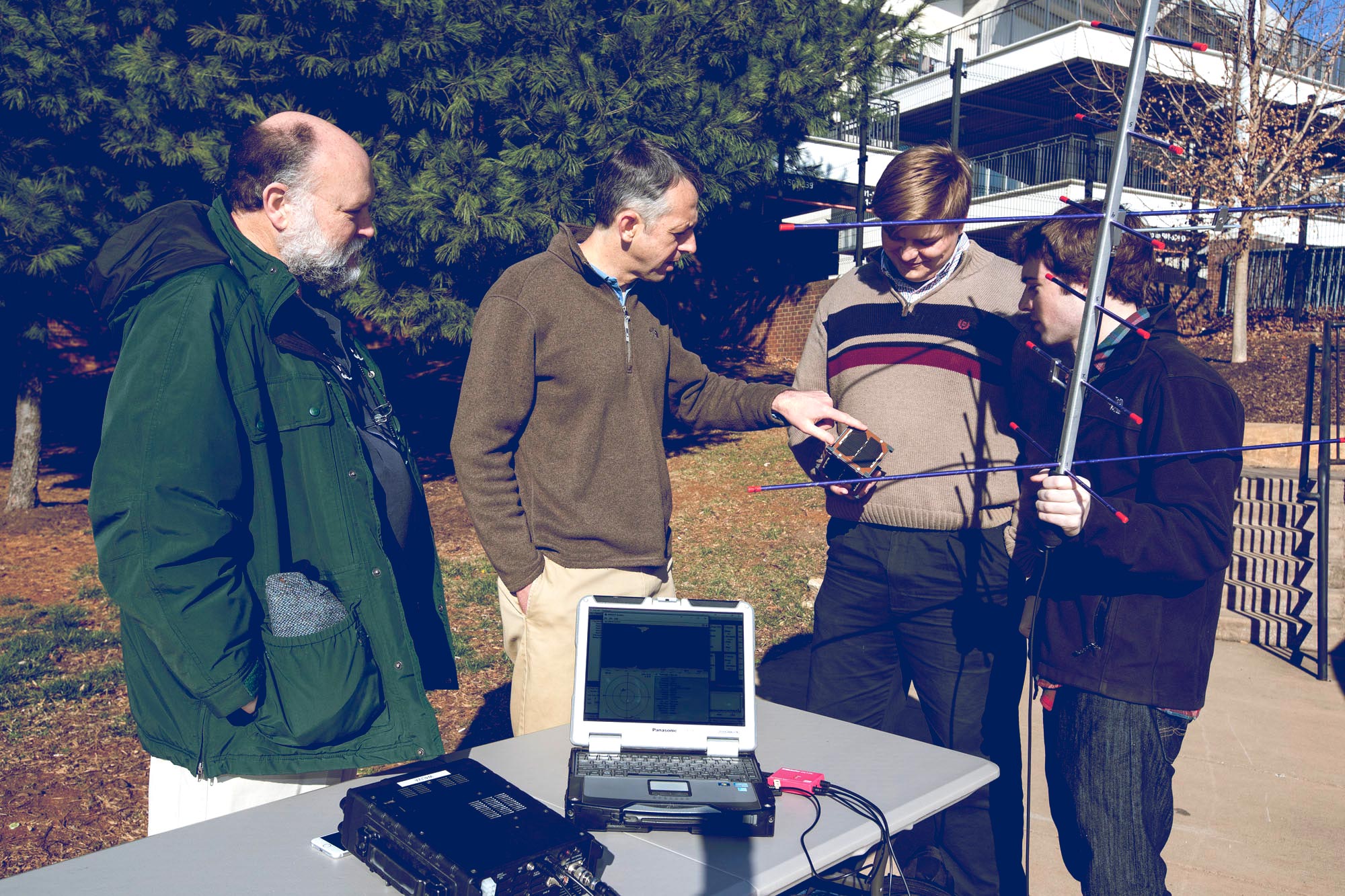 Amateur radio club trustee Michael McPherson, left, Professor Chris Goyne and engineering students Colin Mitchell and Tyler Gabriele, attempt to track a satellite using a UHF radio and hand-held antenna.