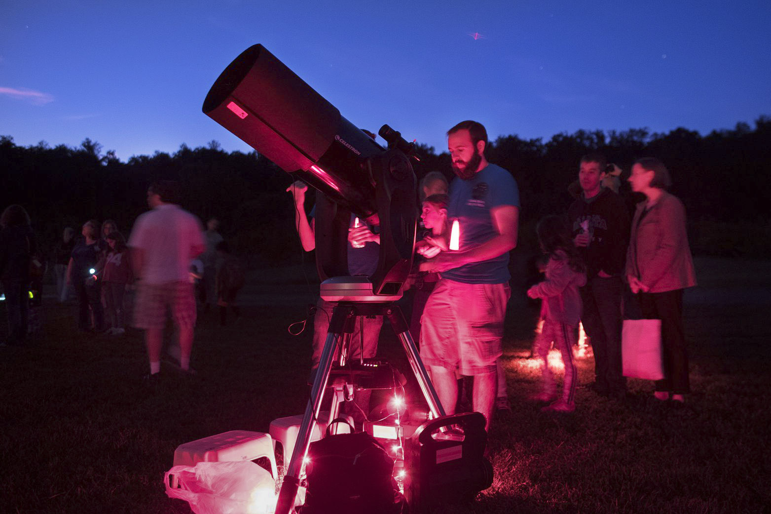 Chris Hayes, helps elementary school students look through a telescope to look at the stars