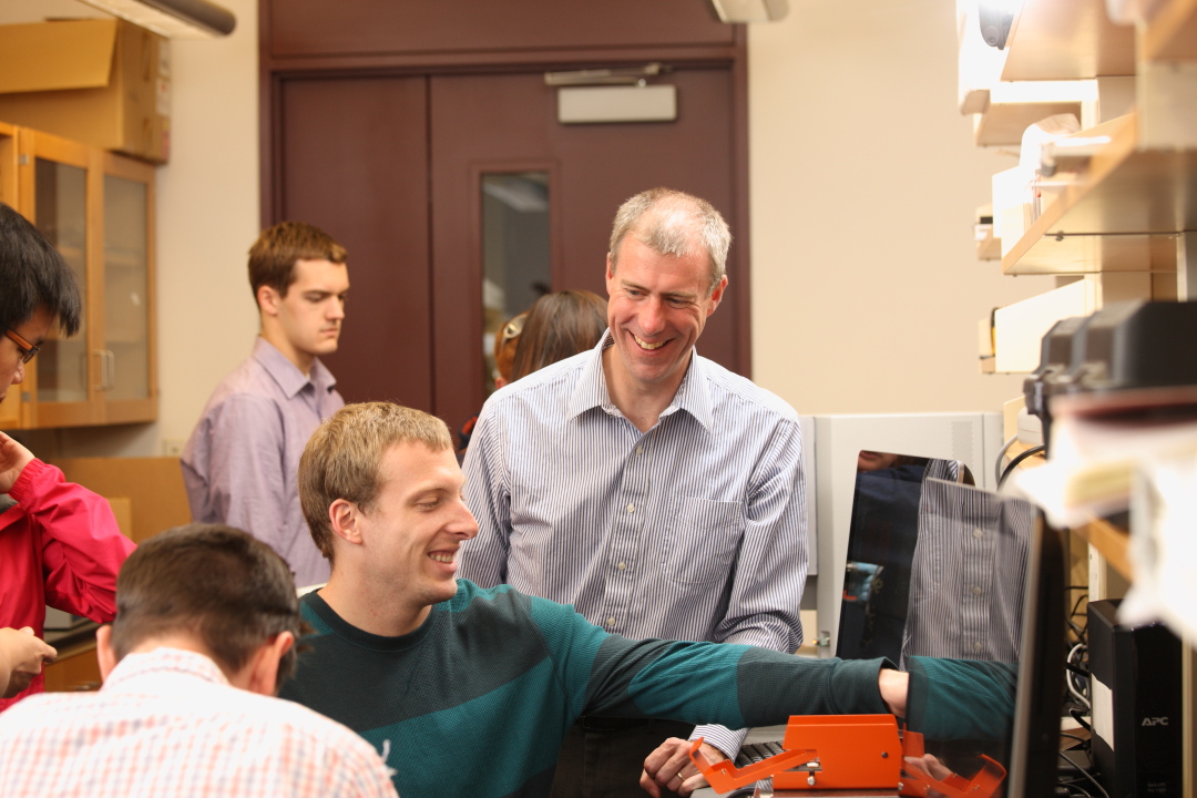 Brian Helmke works with students in a lab