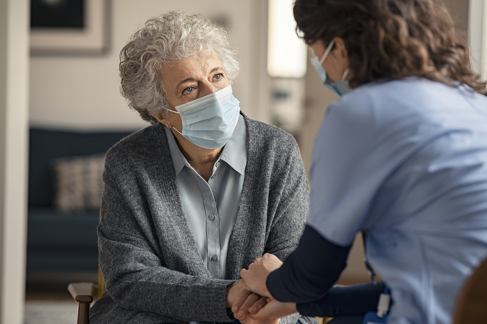 medical professional holding an elderly womans hand