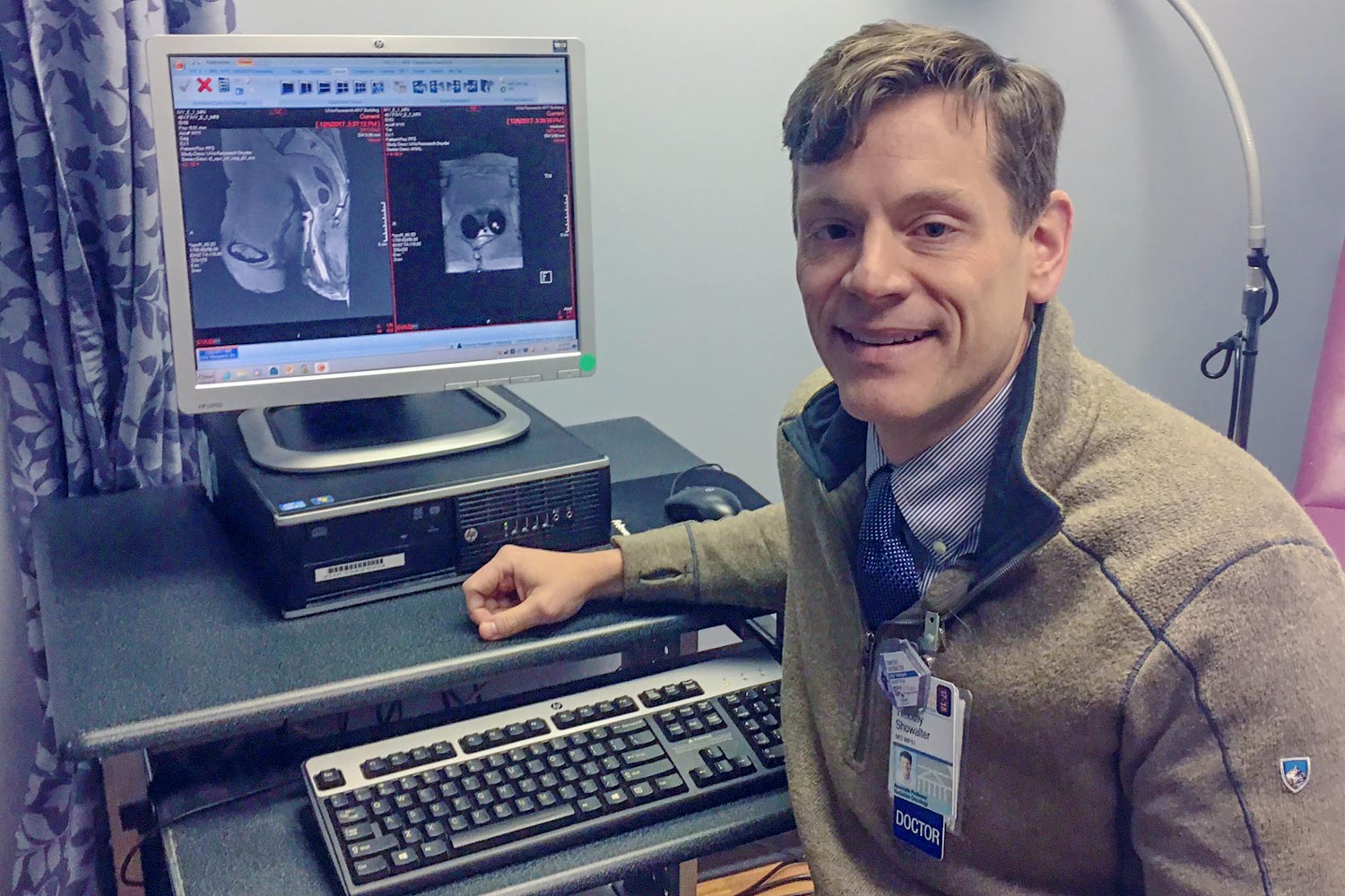 Dr. Timothy Showalter sits in front of a camera with a body scan images on the screen