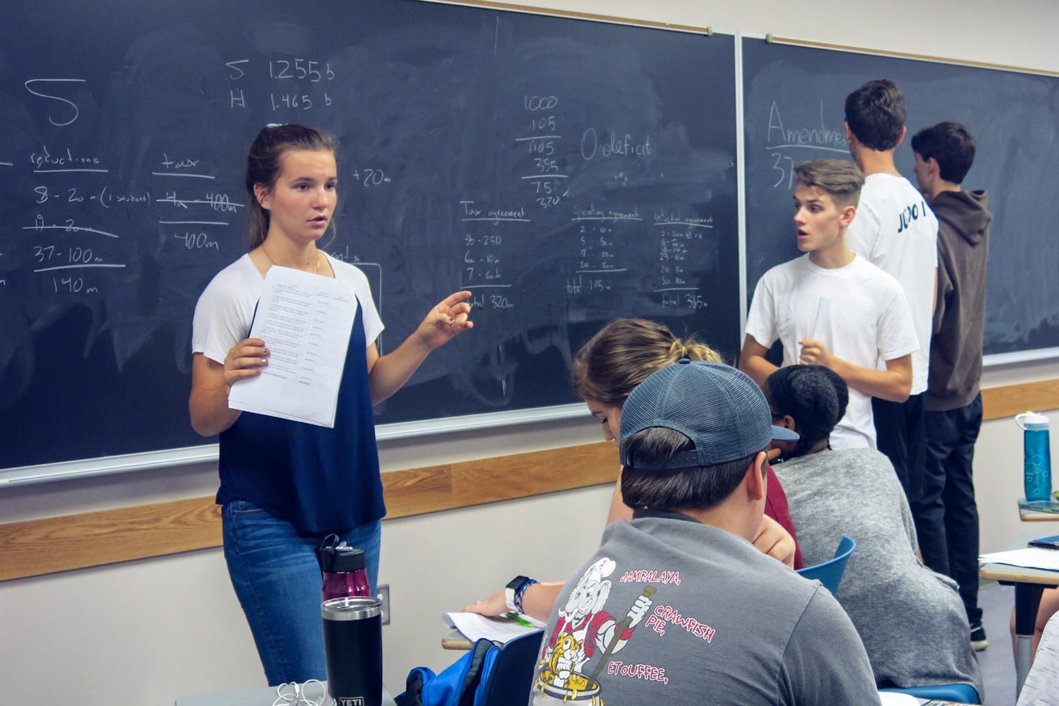 Students working together at desks and chalkboards