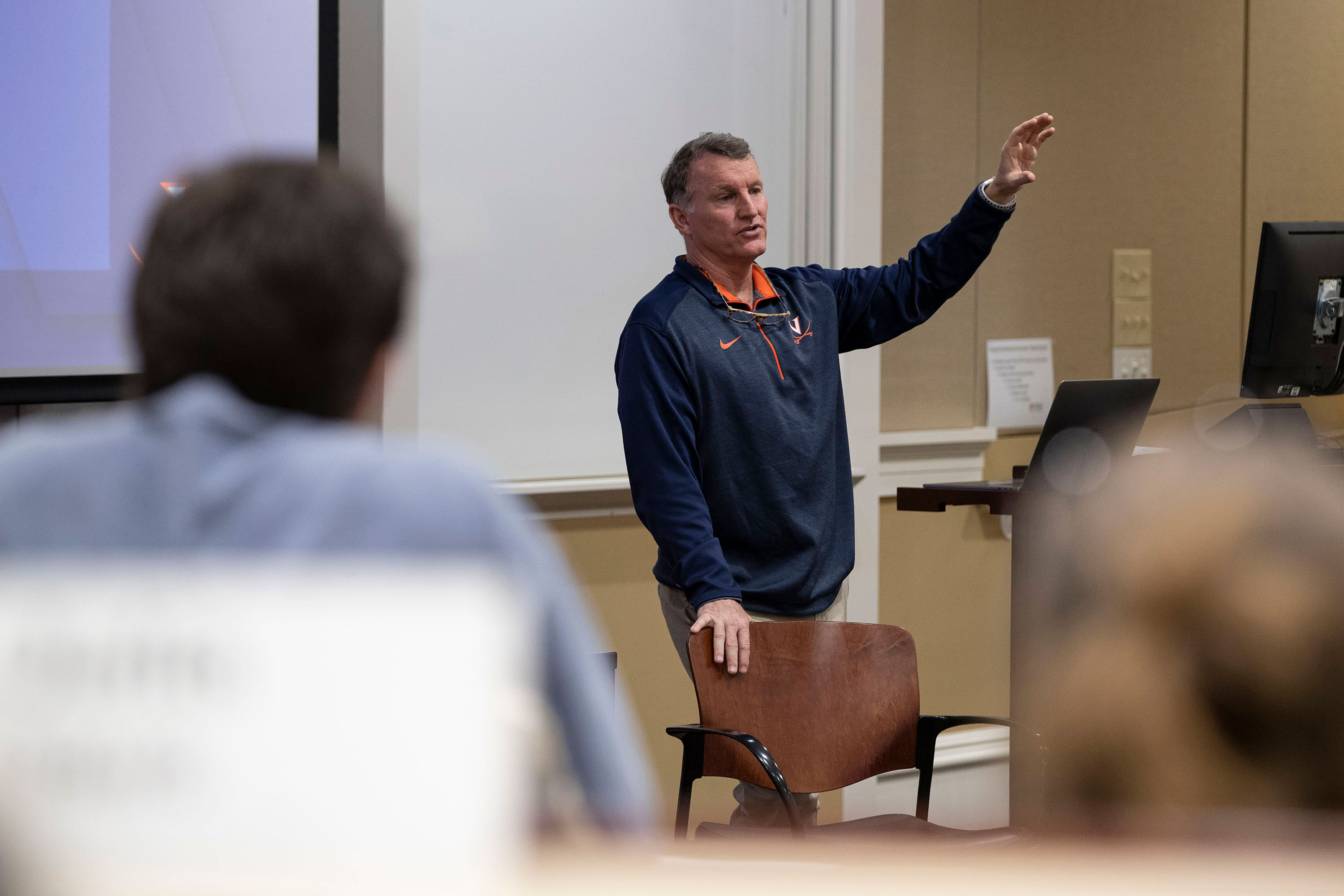 Steve Swanson standing in front of a class speaking with his hand raised