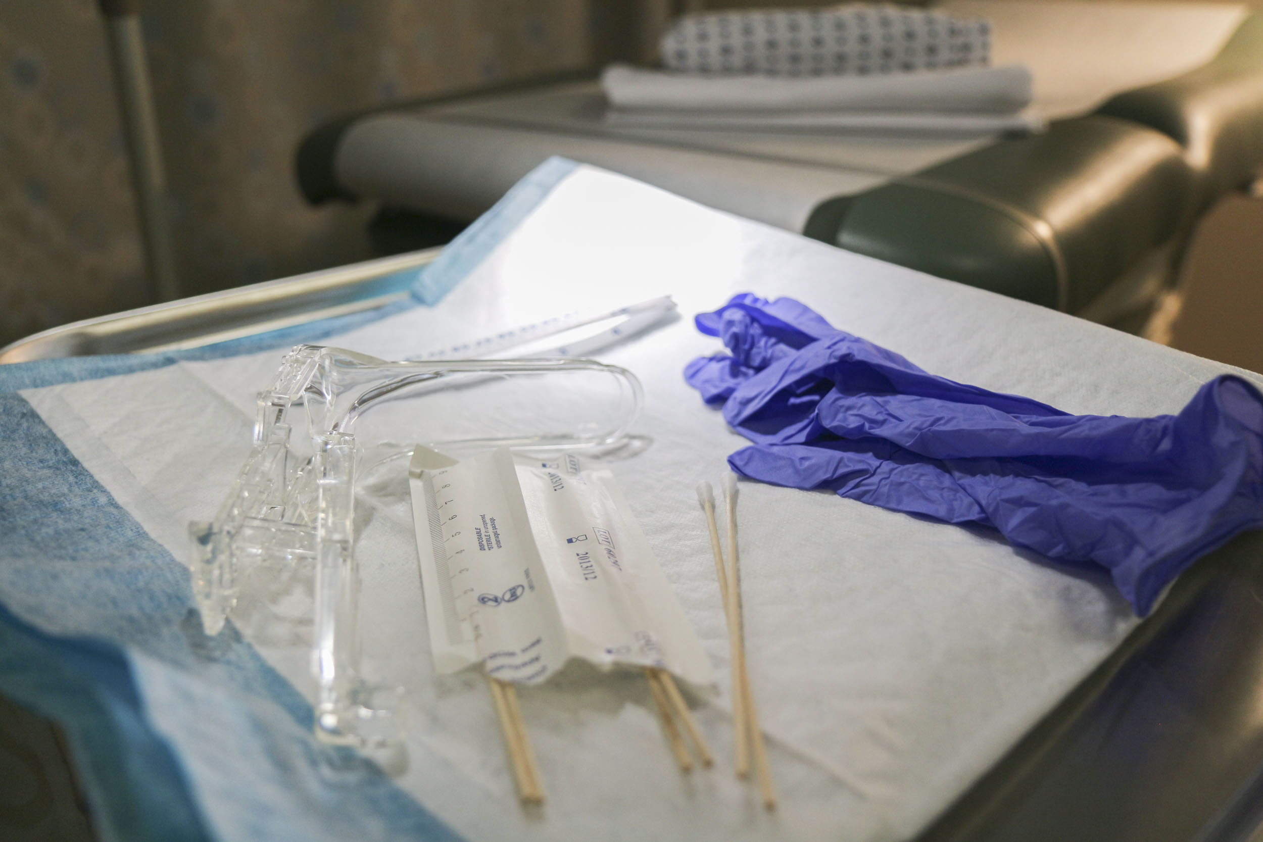 Medical Table with sterile gloves, sterile long q-tips, and a plastic tube
