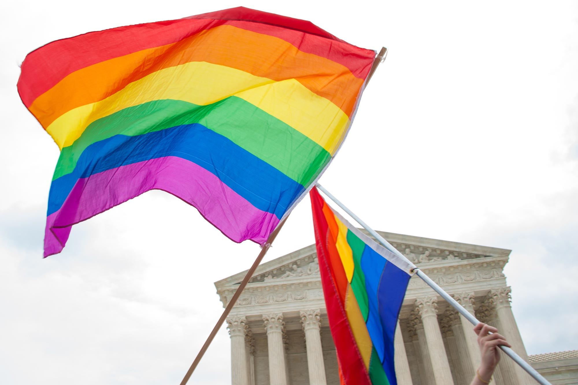 LGBTQ flags being waved in front of the Rotunda