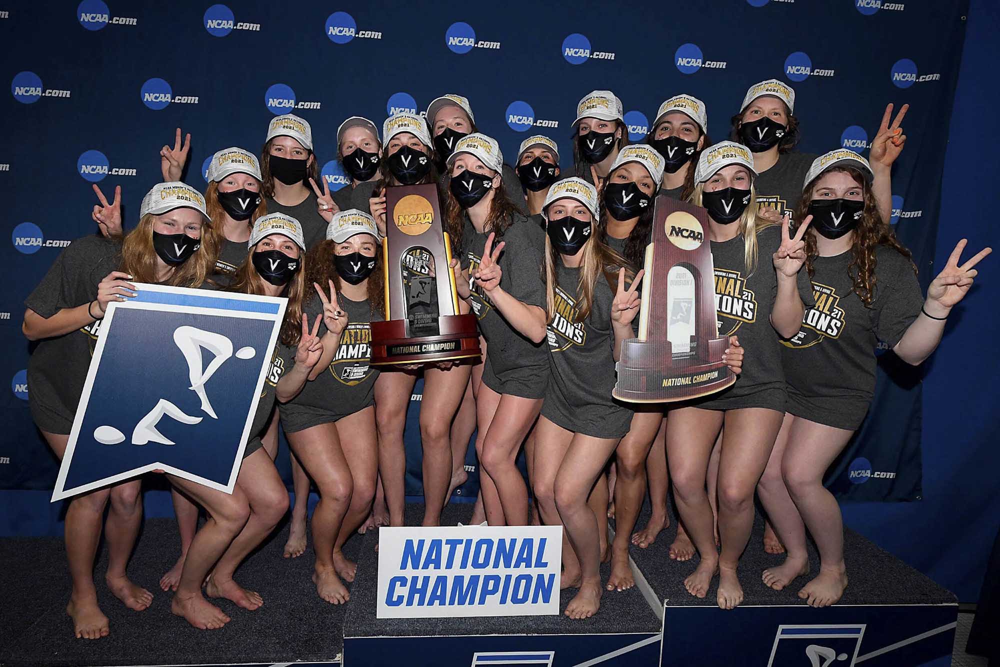 The UVA women’s swimming and diving team pose together with their trophy