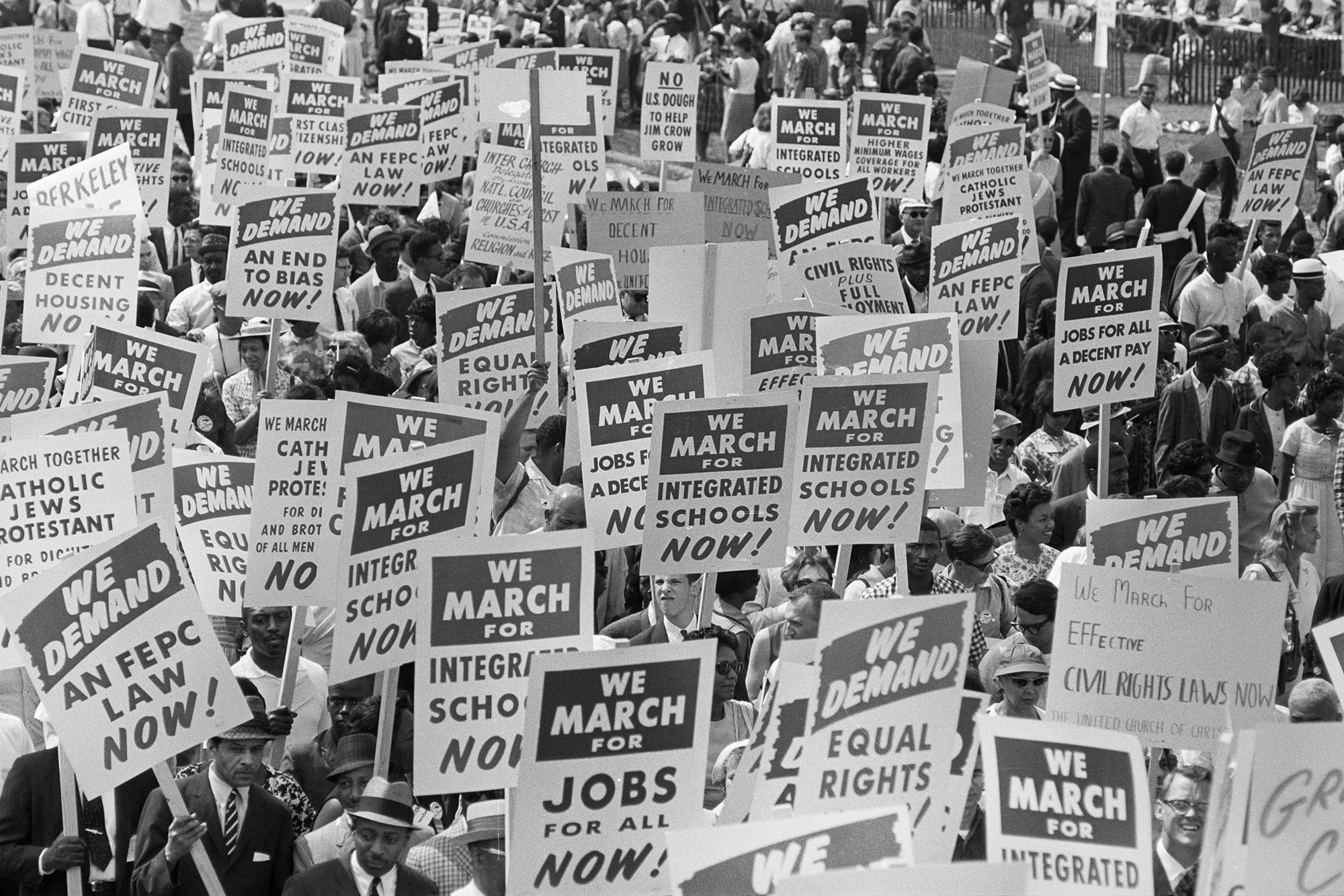 Black and White image of the 1963 March on Washington for Jobs and Freedom.  Protestors carrying various signs
