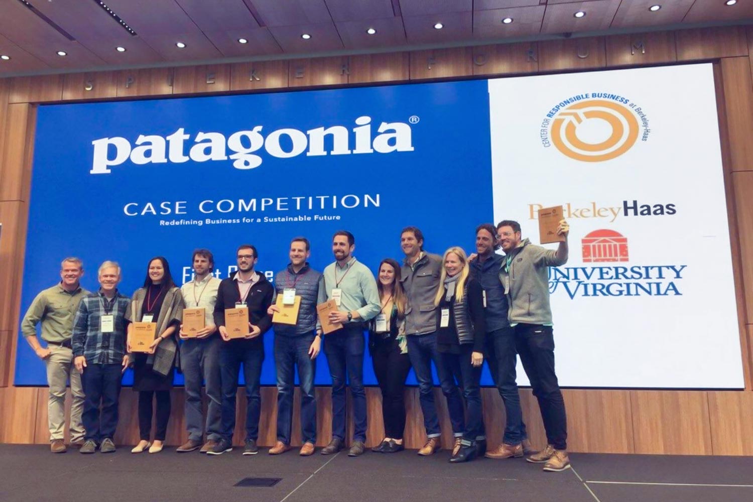 UVA team stands on stage holding their awards after a case competition