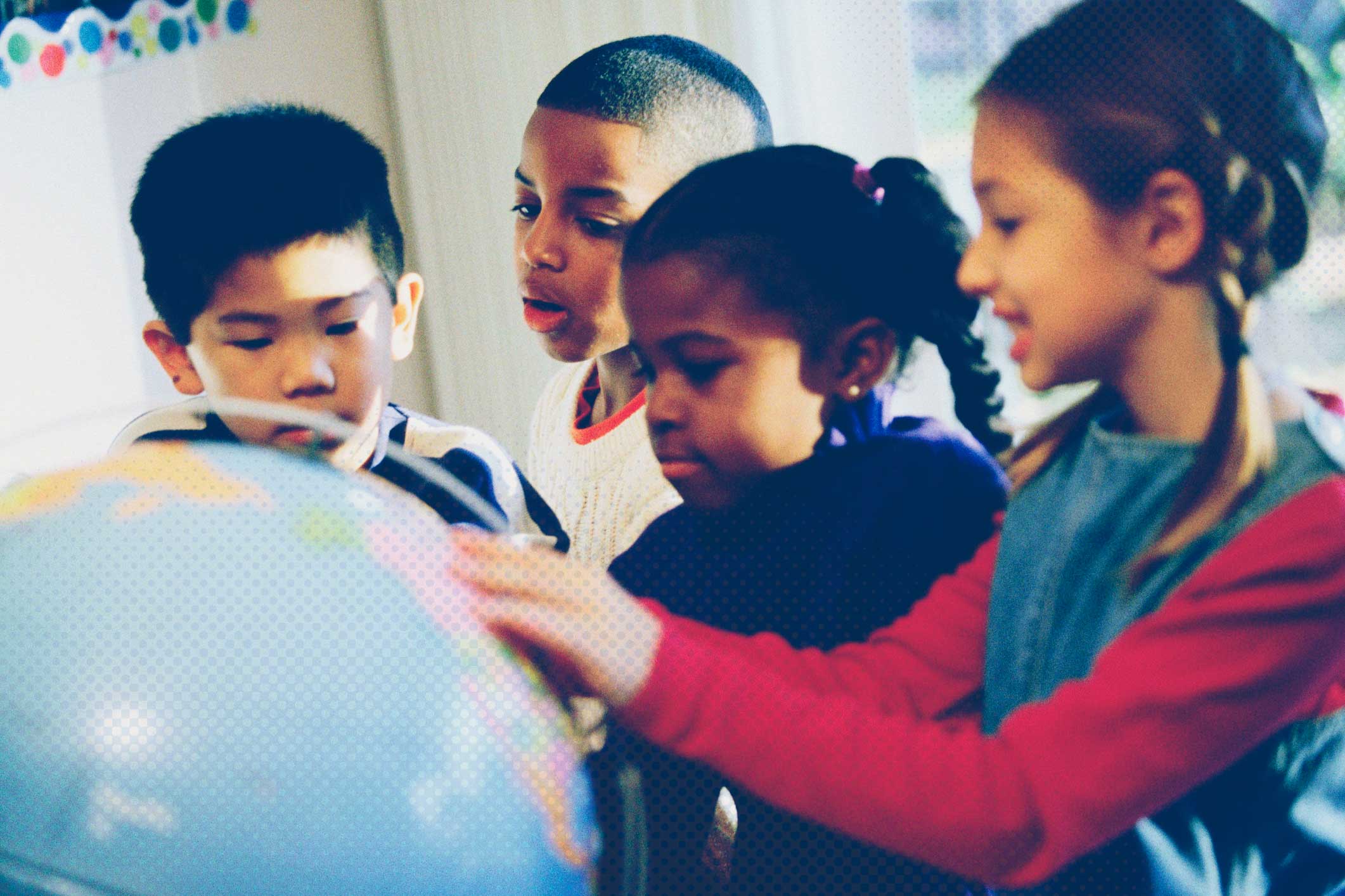 Students playing with a globe on a table