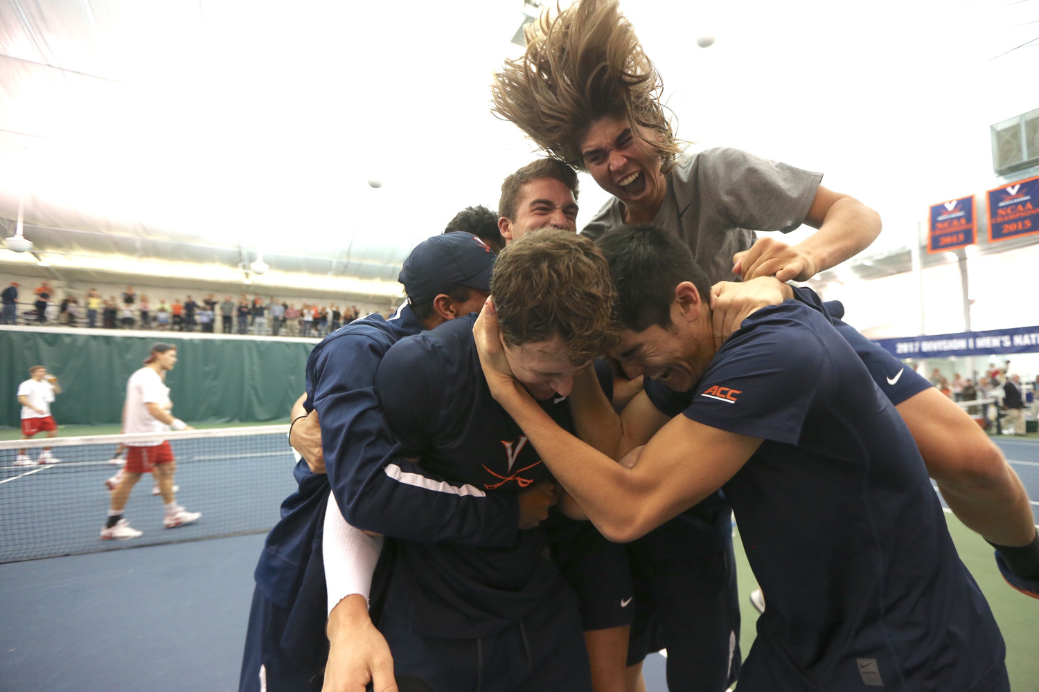 UVA Tennis team huddles together after victory on a match