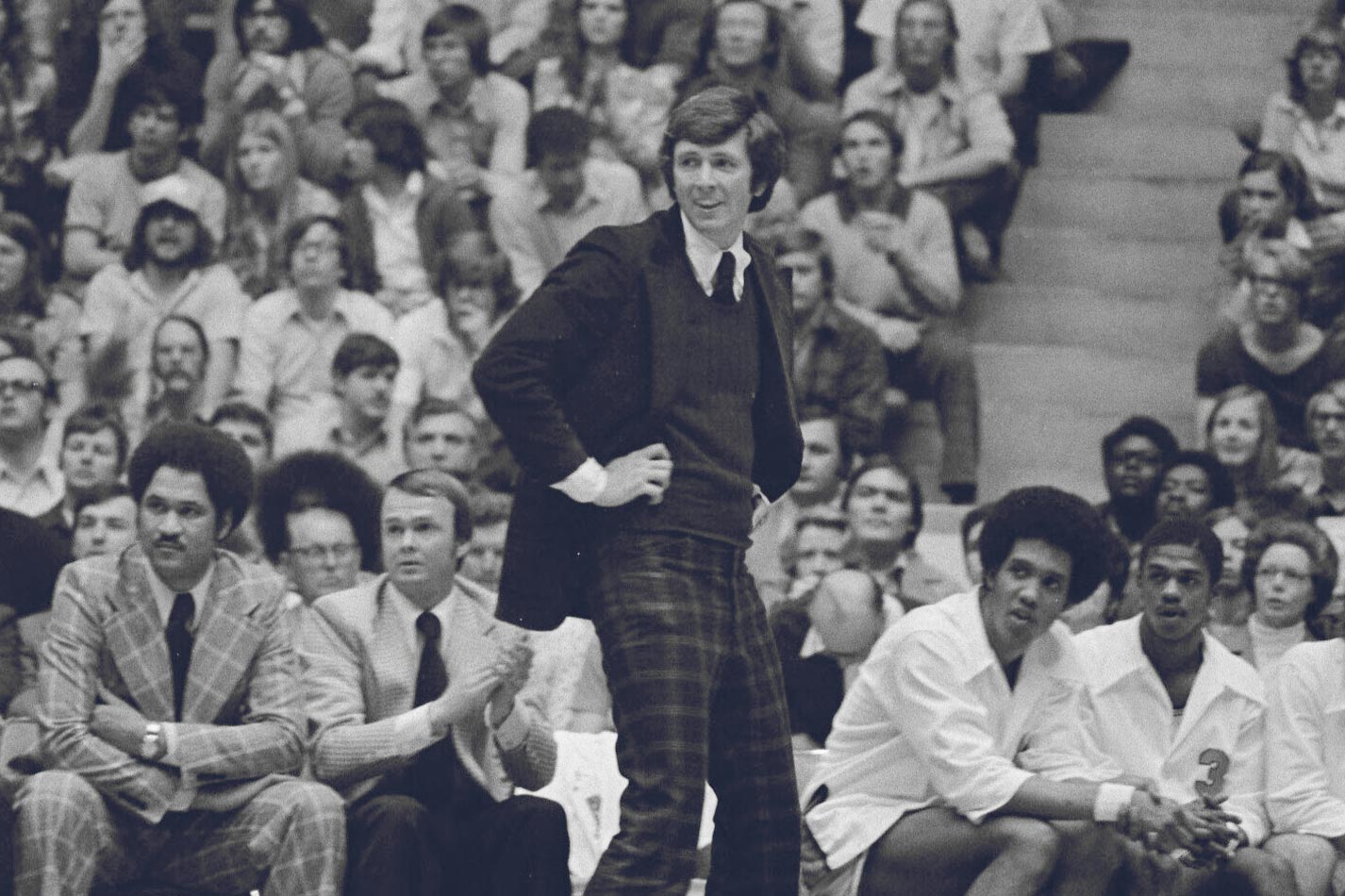 Terry Holland standing watching his basketball team play. Black and White image