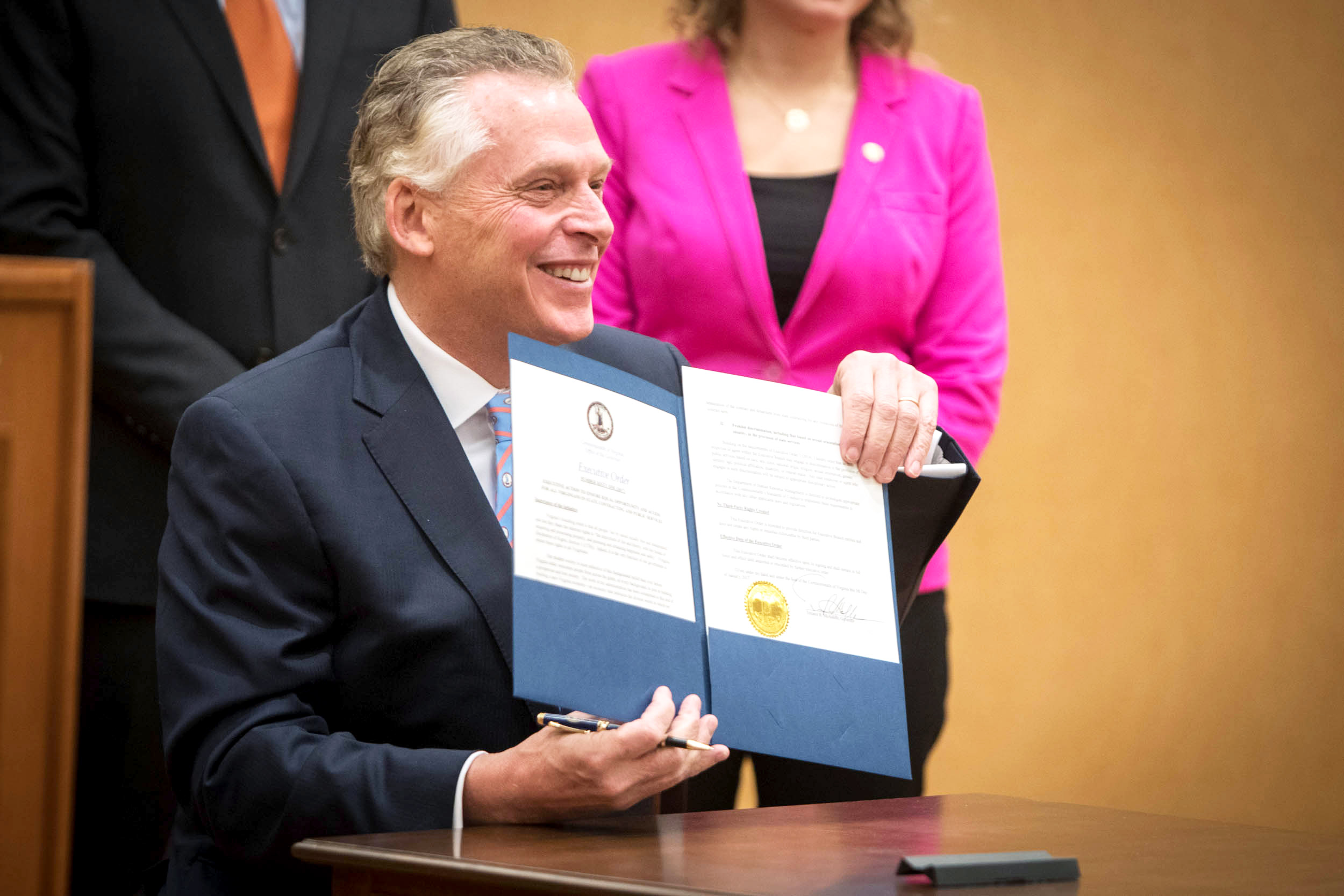 Gov. Terry McAuliffe holds up an executive order he signed