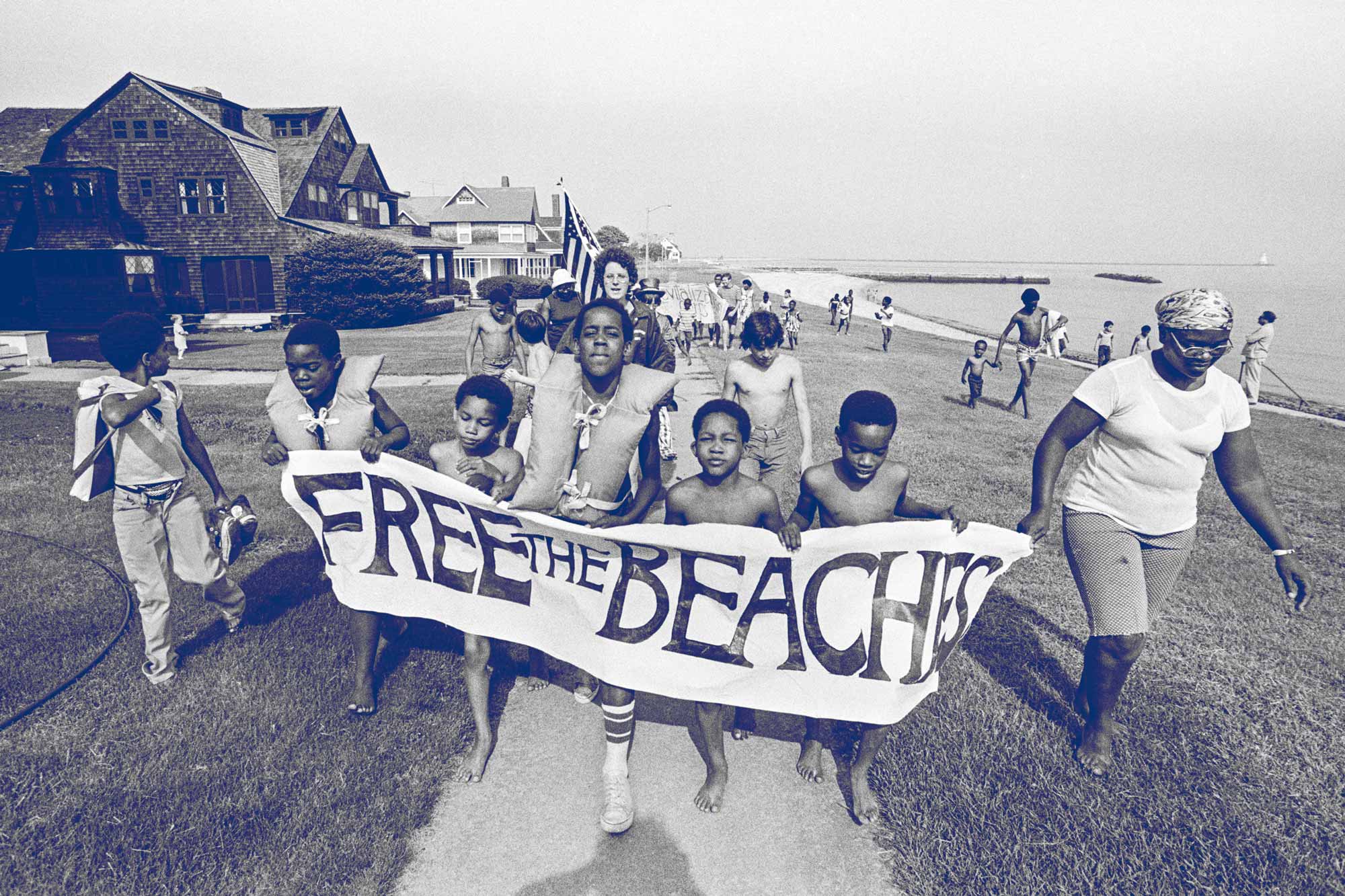 Parents and children hold a sign that says Free the Beaches
