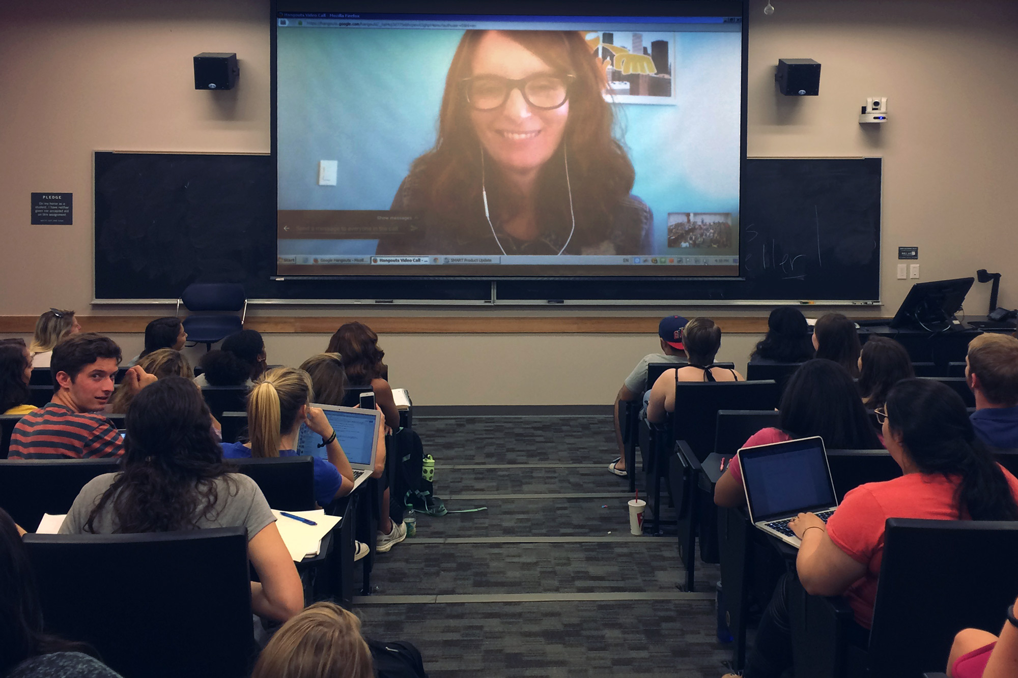 Students watching Tina Fey on a screen
