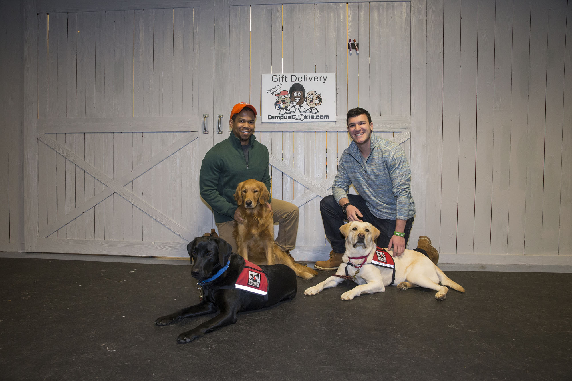 Totem founders P.J. Harris, left, and Kyle Matthews kneel on the ground with three dogs