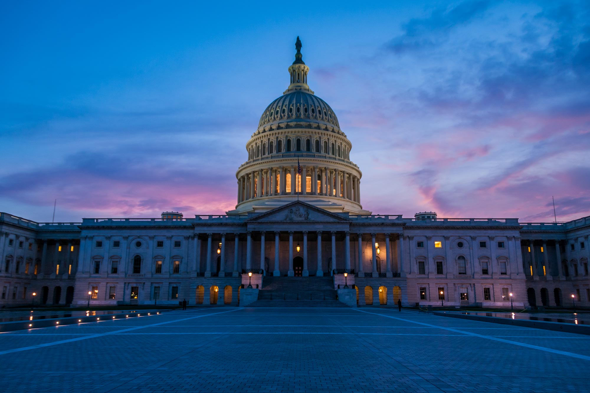 United States Capital building at dusk with a pink, purple, and blue sky