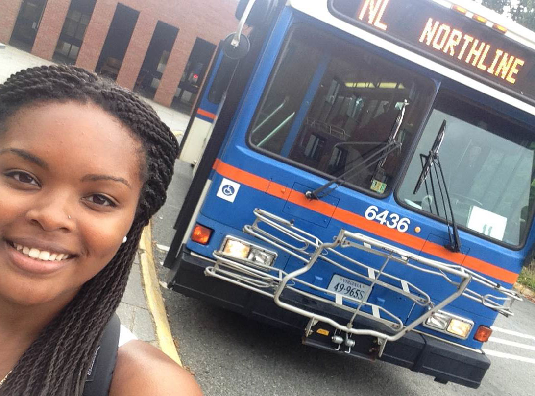 Alexis Taylor takes a selfie in front of a UVA bus